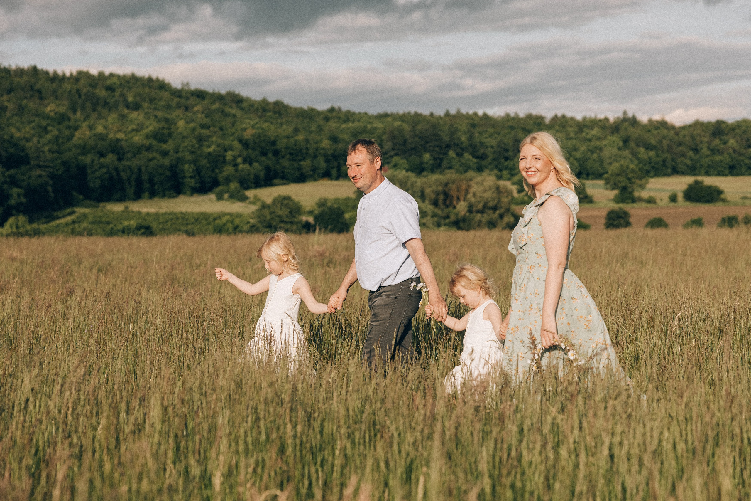 Family photoshoot in a daisy meadow at golden hour — natural light, warm tones, candid moments between a mother and her daughters. Lifestyle and Family Photographer in Pisek Oxana Telupilova