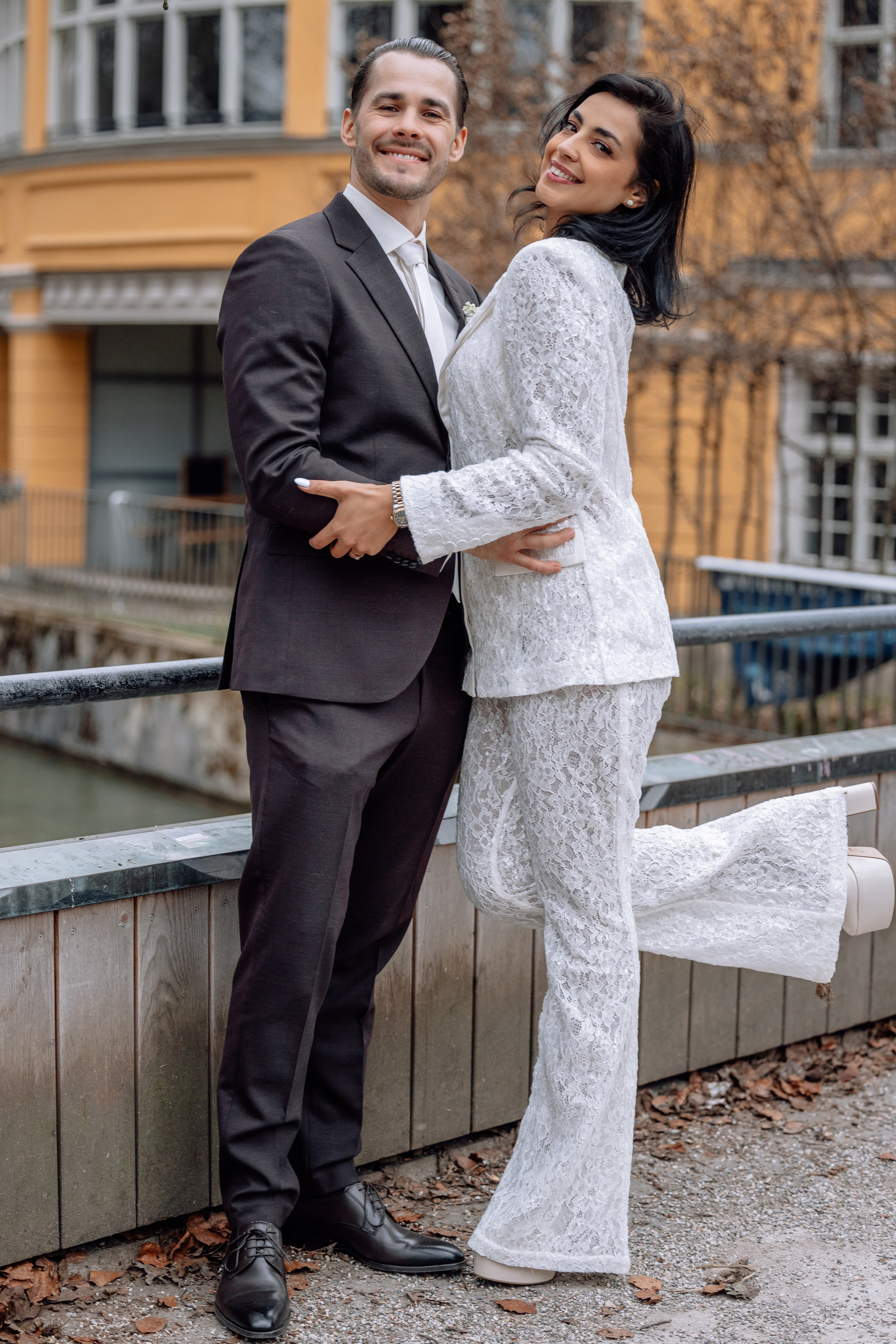 Brautpaar posiert vor Standesamt Mandlstraße 14 – romantische Hochzeitsszene