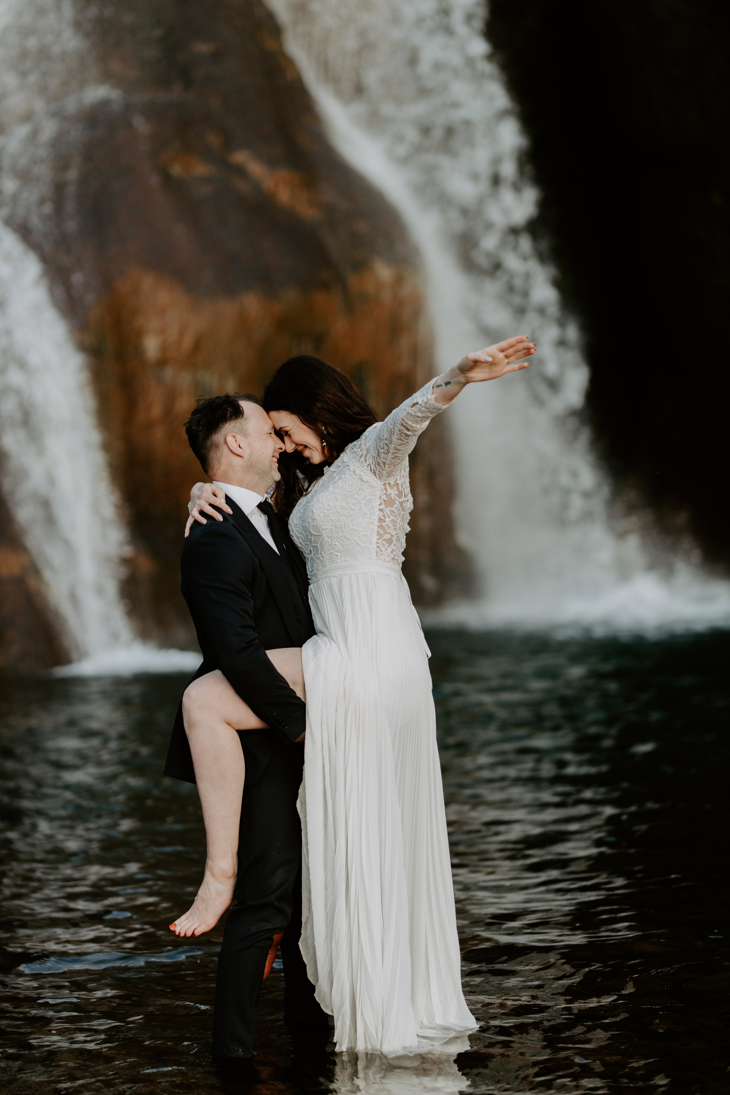 Love in the wild—couple sharing a quiet moment in front of a majestic Icelandic waterfall.