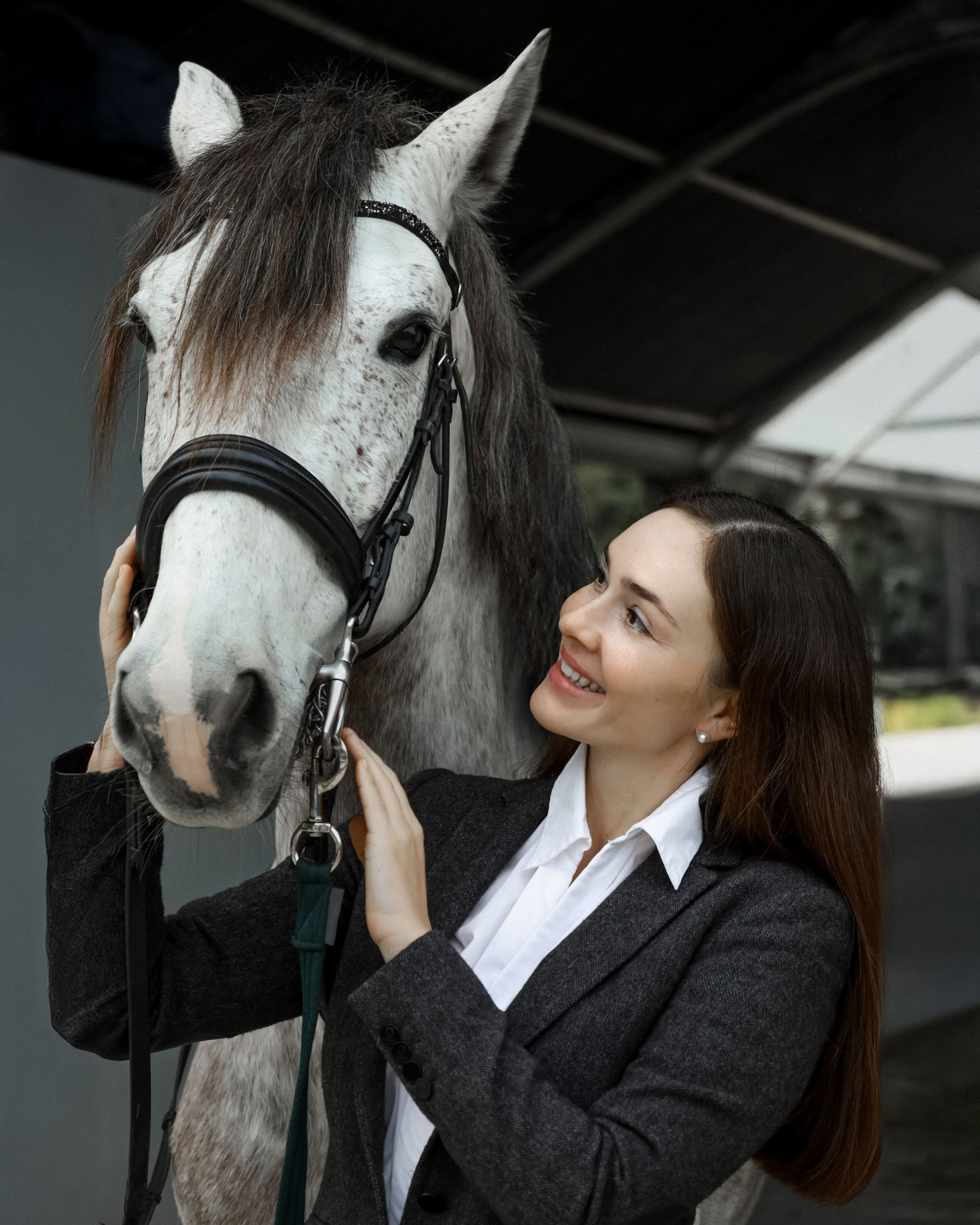 Retrato romántico de una chica con su caballo en las caballerizas.