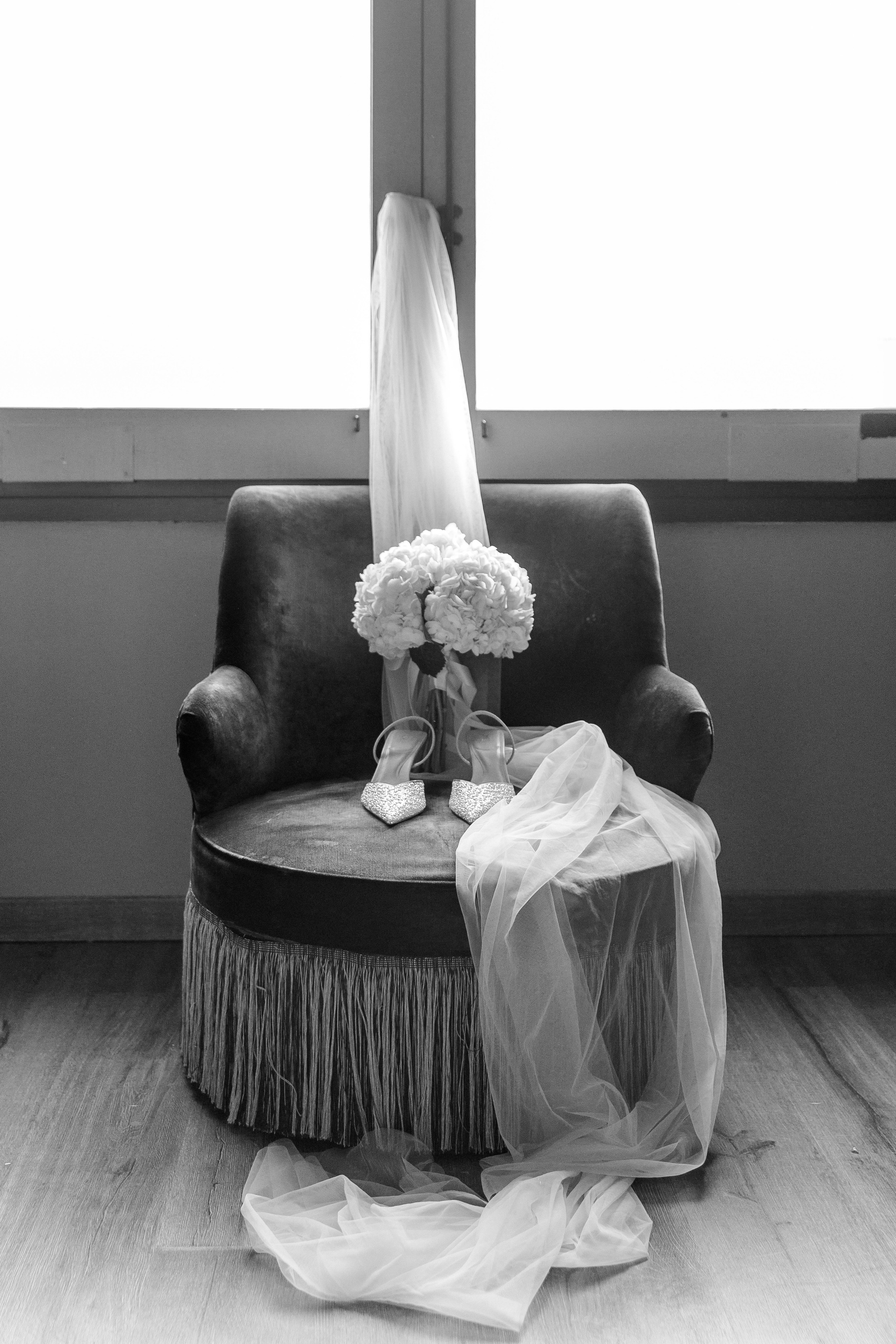Stylish bridal shoes and bouquet placed next to the wedding veil, showcasing the details for a destination wedding