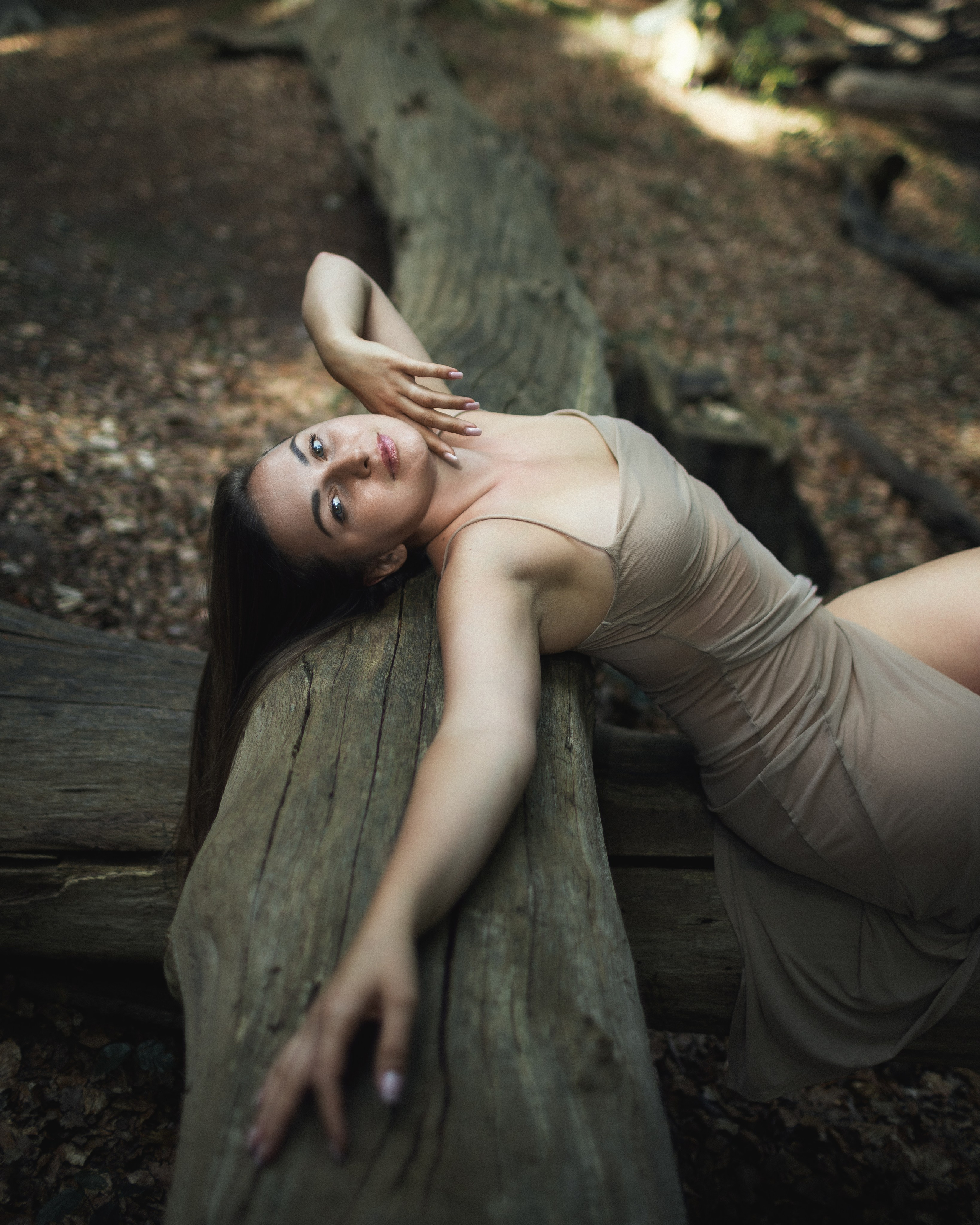 Portrait von Anastasija auf einem Holzstamm im Wald – natürliche Fotografie in Gifhorn