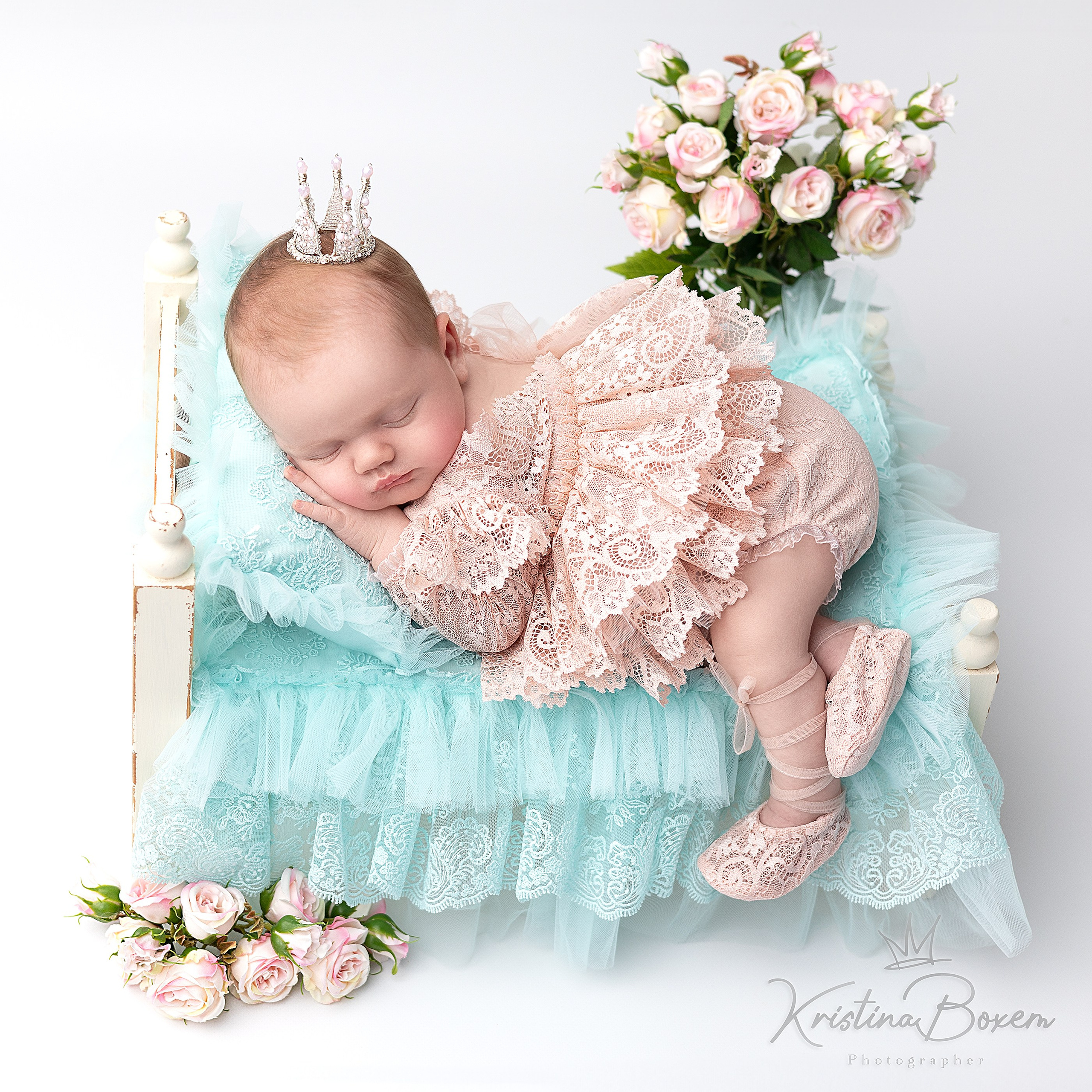 Slapende pasgeboren prinses met een kroon op een luxe bed – een lieve, sprookjesachtige newborn fotoshoot door Kristina Boxem.