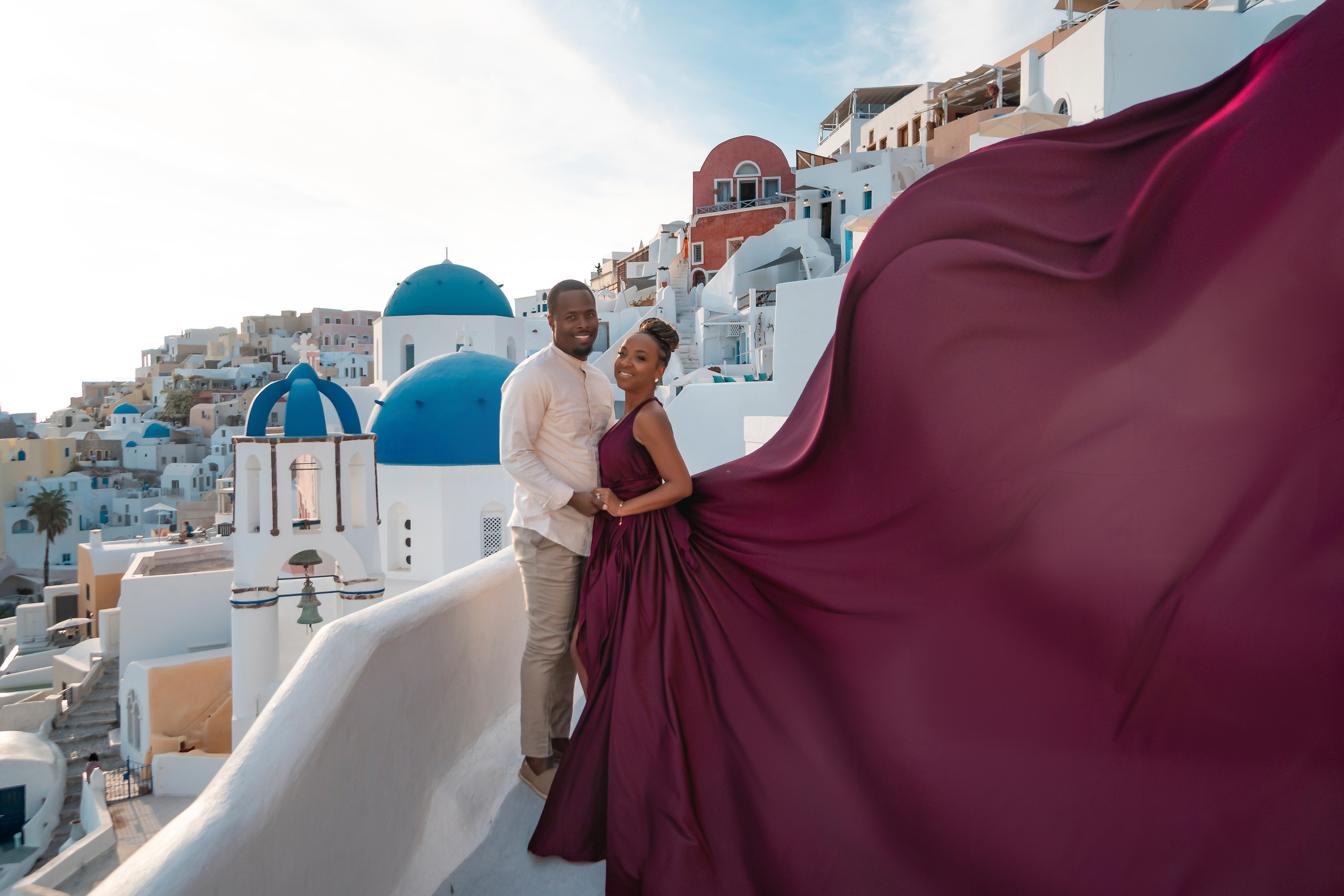 Photo session in Oia, Santorini at sunset, cherry flying dress. Photographer in Santorini SokoLOVE Alex| Flying Dress Santorini