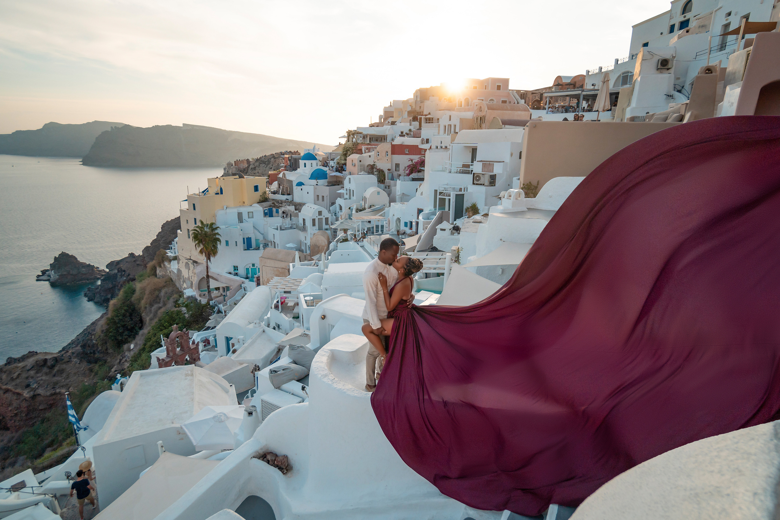 Photo session in Oia, Santorini at sunset, cherry flying dress. Photographer in Santorini SokoLOVE Alex| Flying Dress Santorini