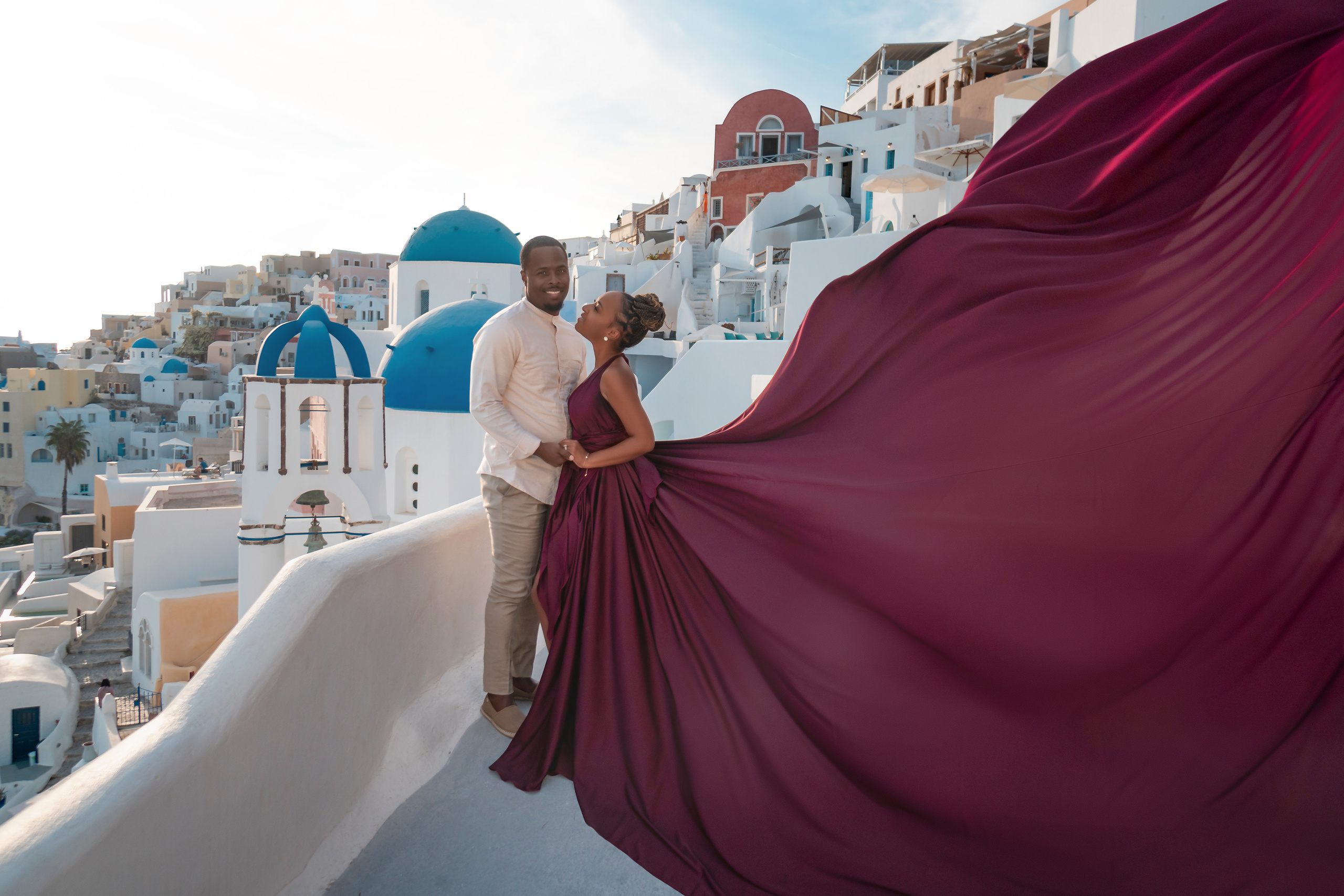 Photo session in Oia, Santorini at sunset, cherry flying dress. Photographer in Santorini SokoLOVE Alex| Flying Dress Santorini