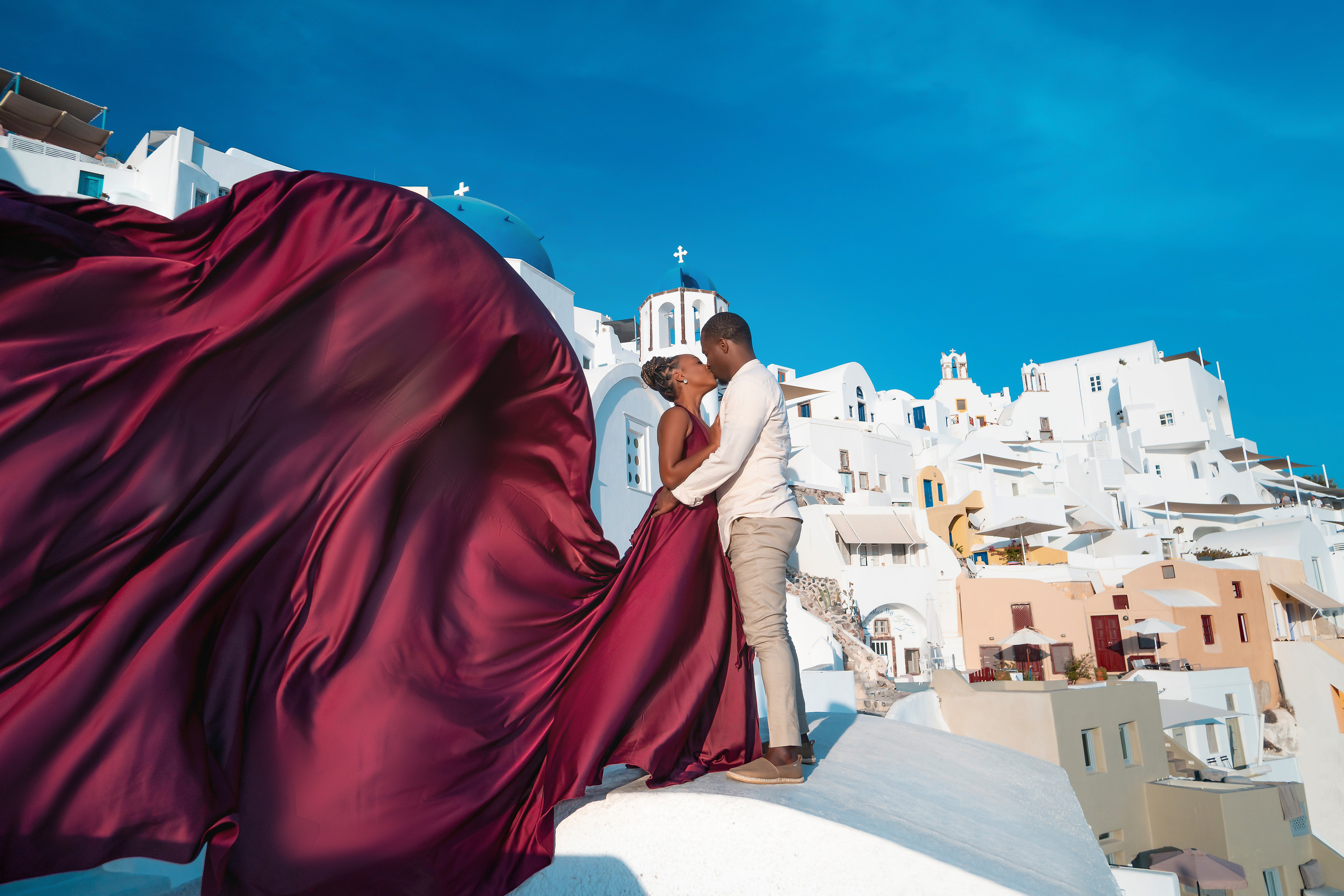 Photo session in Oia, Santorini at sunset, cherry flying dress. Photographer in Santorini SokoLOVE Alex| Flying Dress Santorini