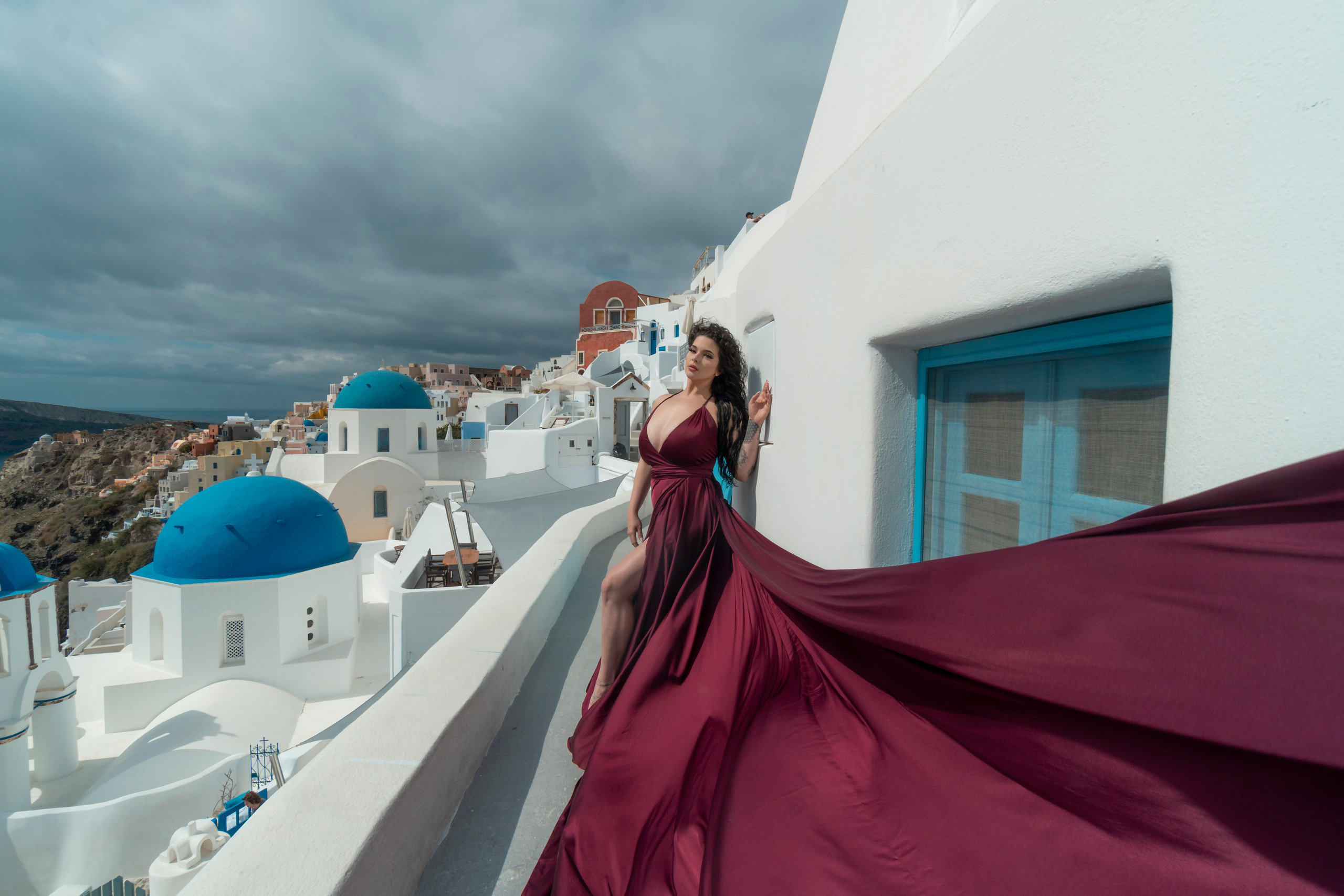  cherry "Flying Dress Backless Santorini" featuring a sensual bare-back design. Available in sizes XS-L for unforgettable photoshoots in breathtaking locations