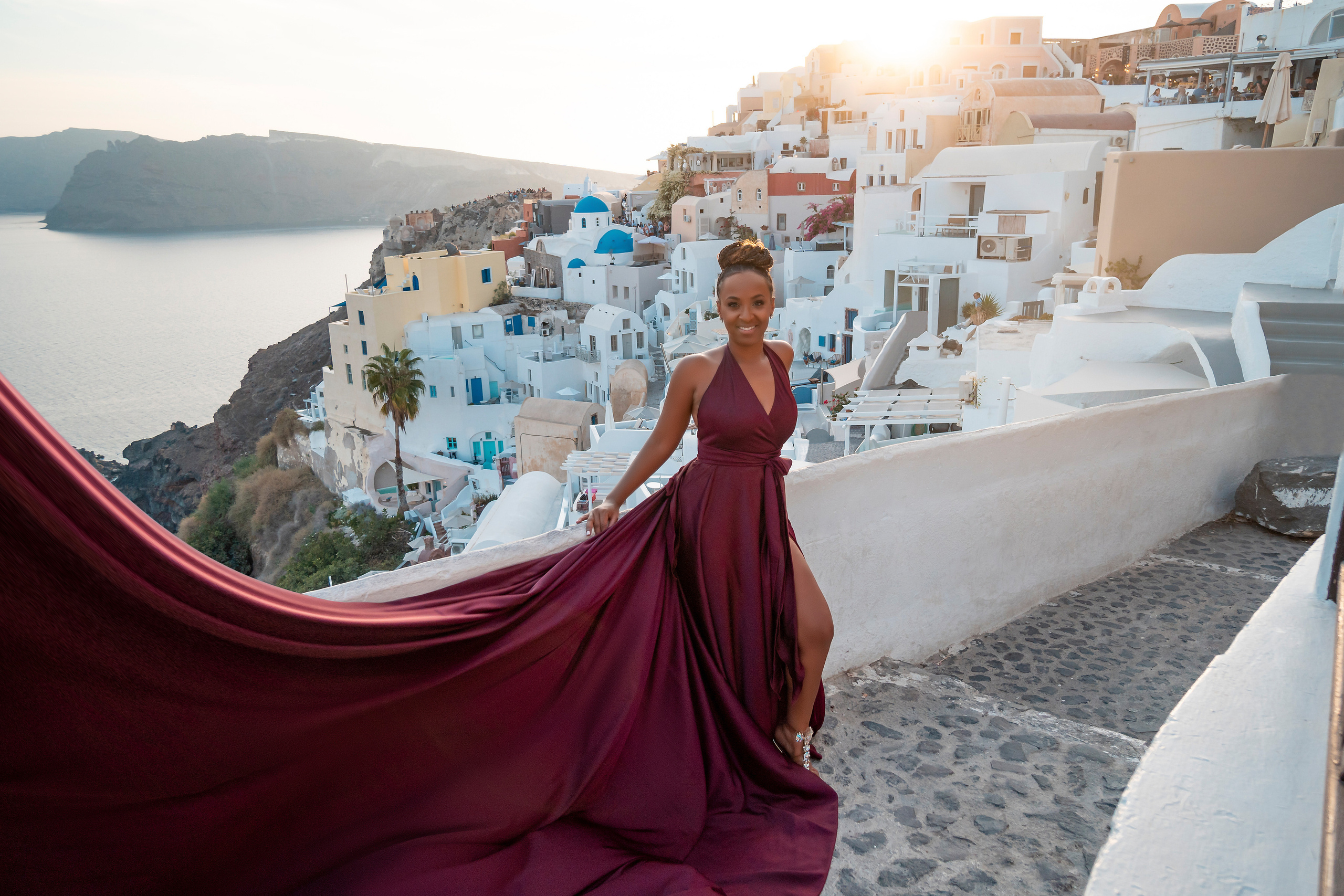 Photo session in Oia, Santorini at sunset, cherry flying dress. Photographer in Santorini SokoLOVE Alex| Flying Dress Santorini