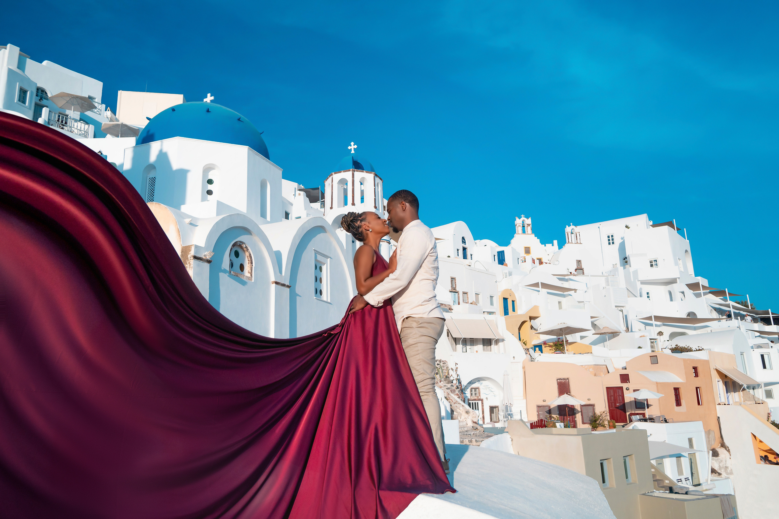 Photo session in Oia, Santorini at sunset, cherry flying dress. Photographer in Santorini SokoLOVE Alex| Flying Dress Santorini