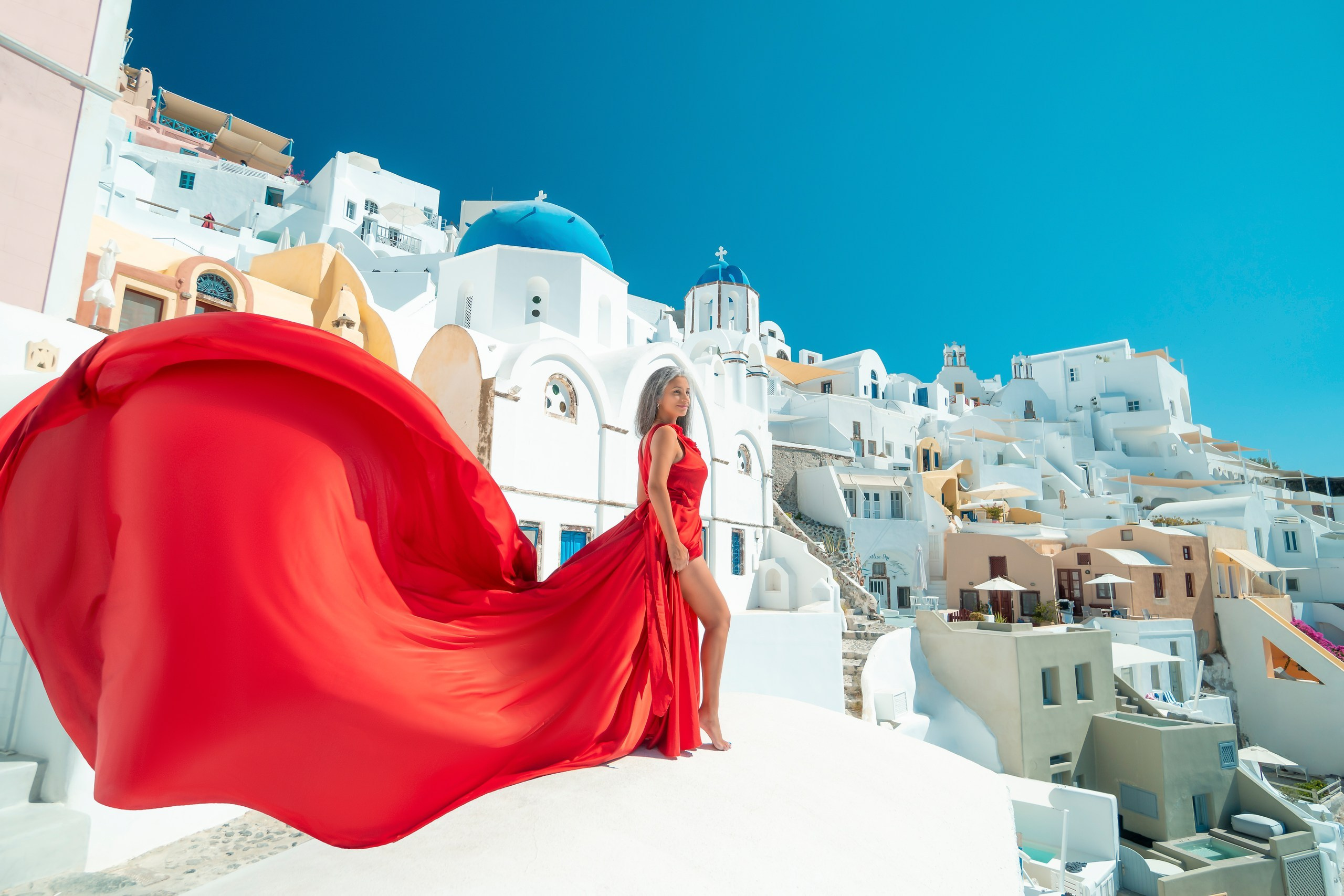 Dynamic movement in red ruffled plus size flying dress, captured mid-twirl on Santorini terrace.