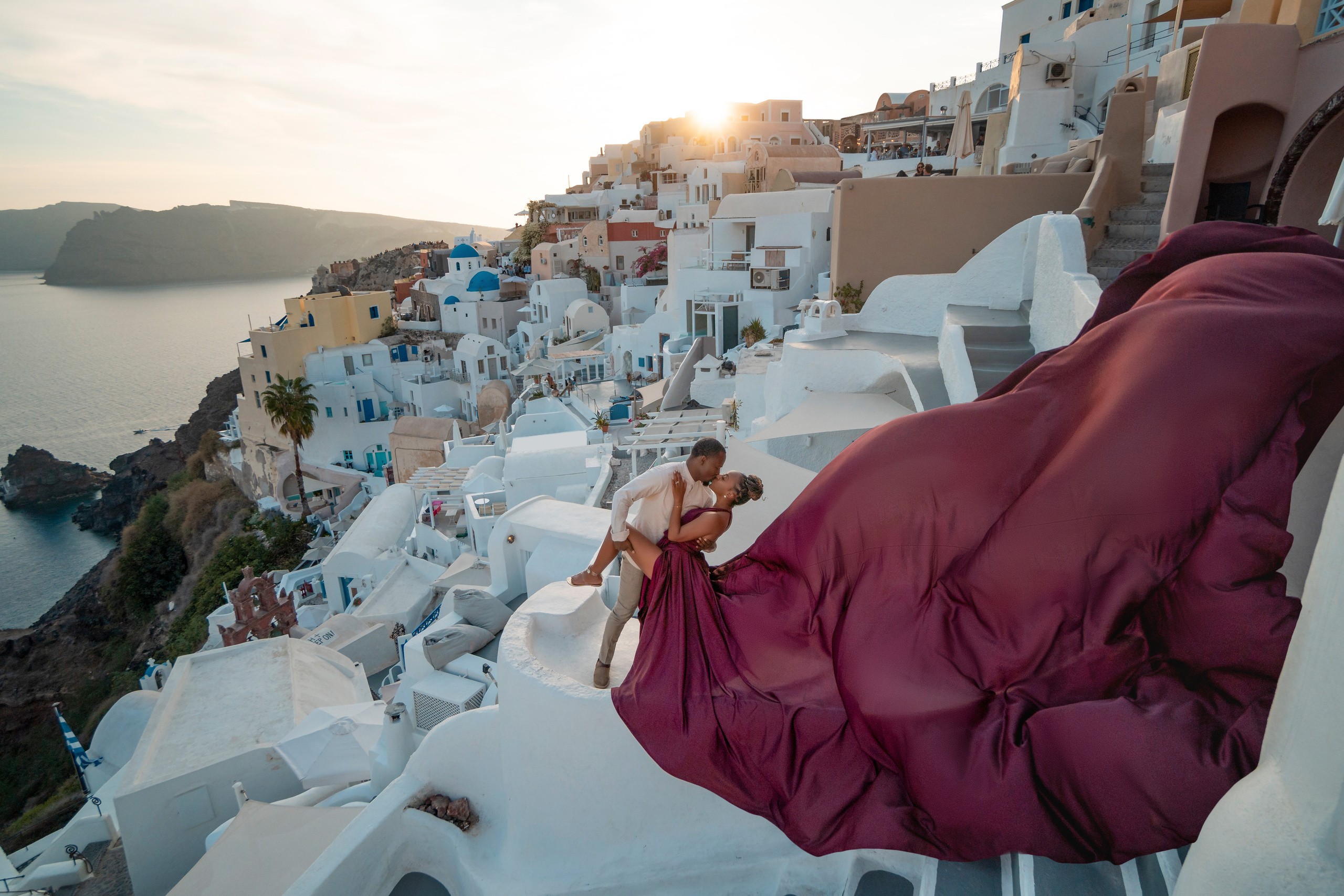 Photo session in Oia, Santorini at sunset, cherry flying dress. Photographer in Santorini SokoLOVE Alex| Flying Dress Santorini