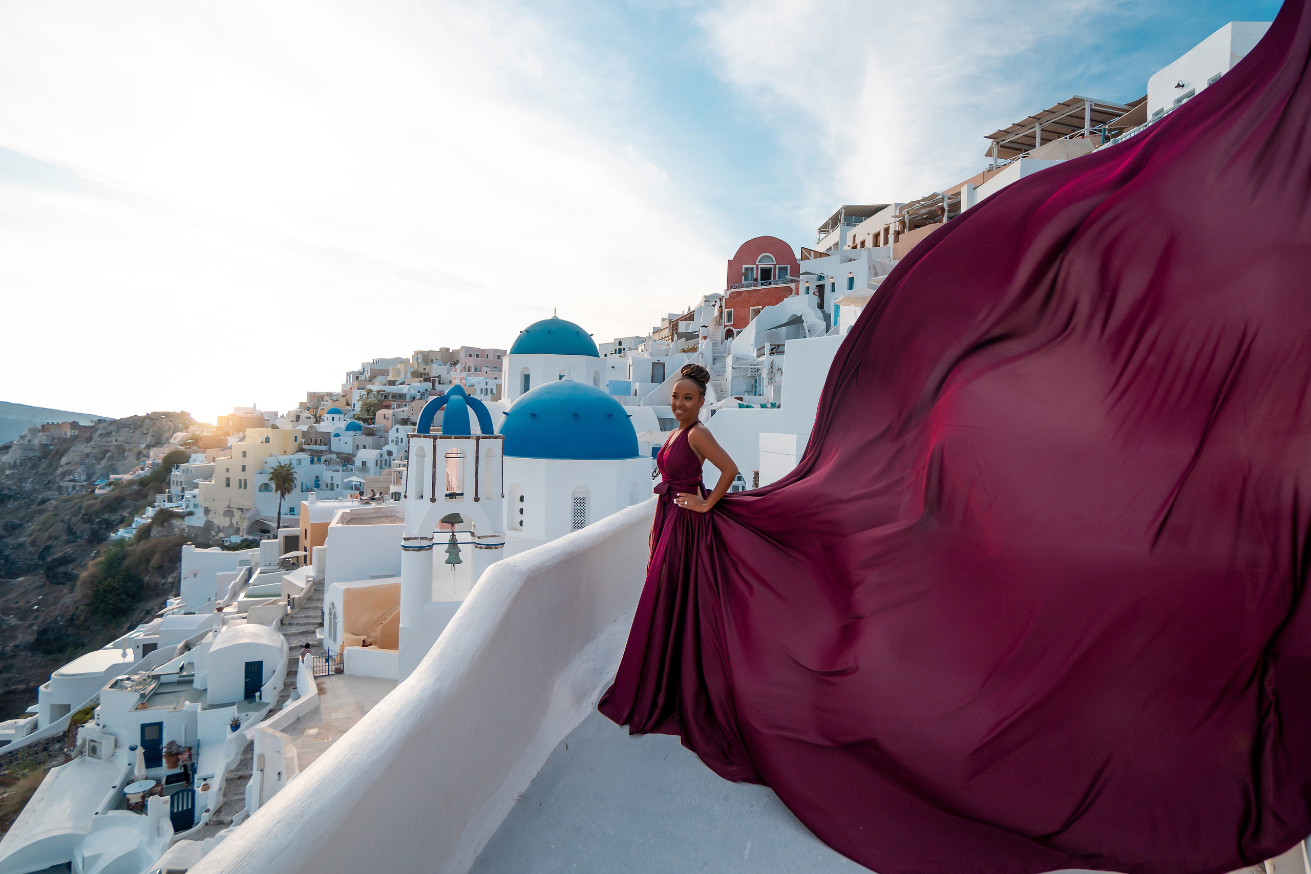 Photo session in Oia, Santorini at sunset, cherry flying dress. Photographer in Santorini SokoLOVE Alex| Flying Dress Santorini