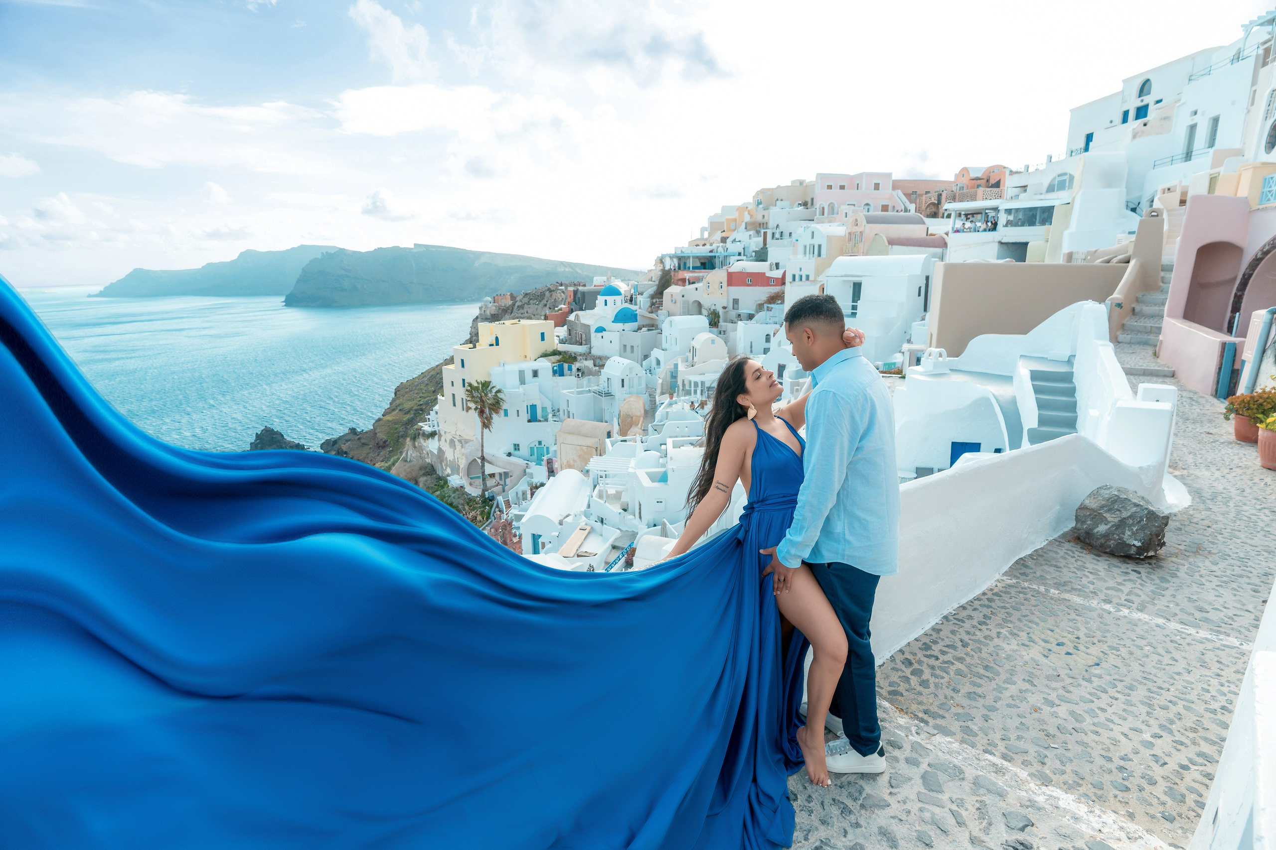 Séance photo à Santorin en mars: Sublimez vos clichés avec une robe volante bleu roi. Photographe vidéaste à Santorin|Séances photos de Robe volante Santorin|