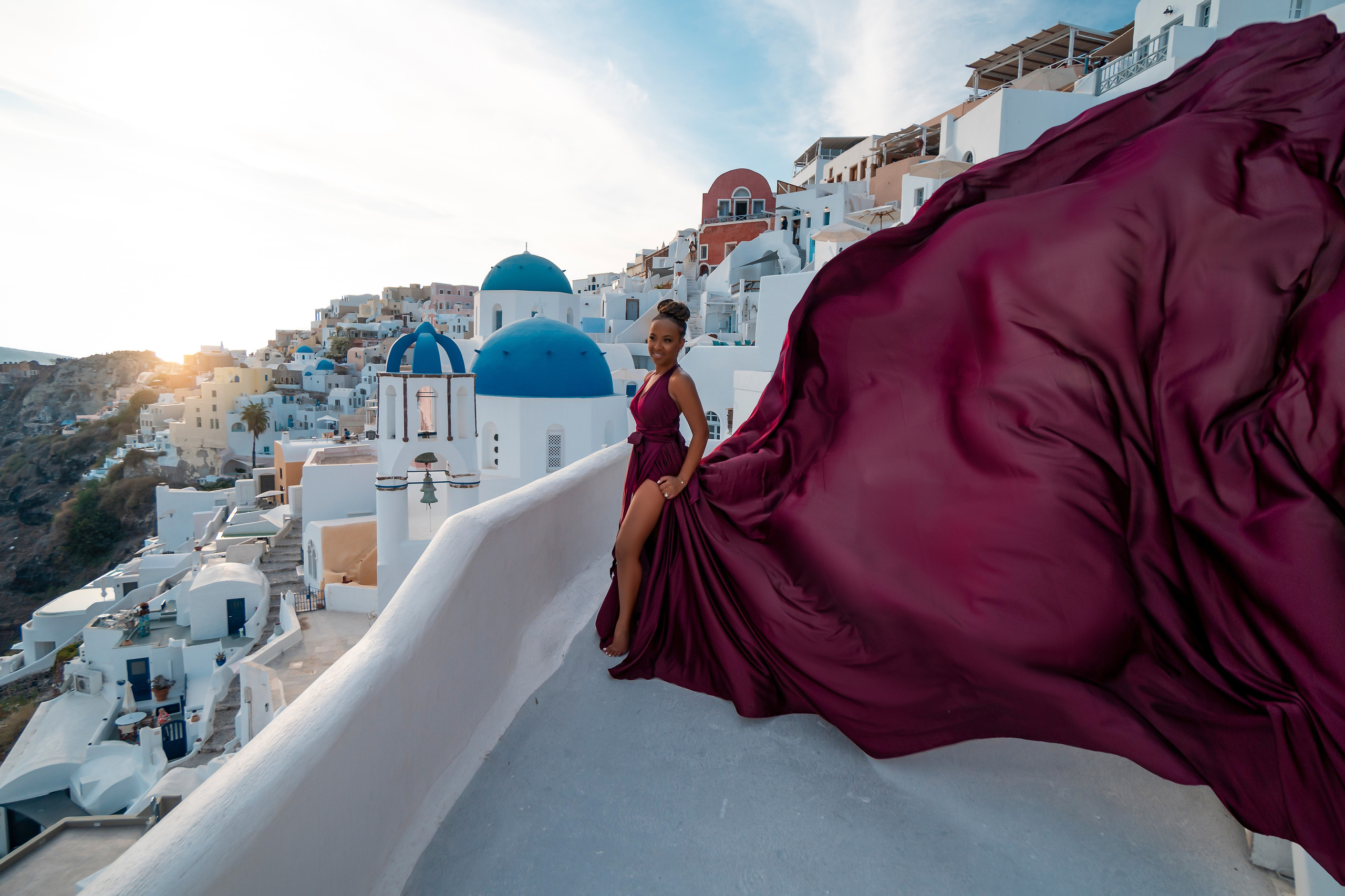Photo session in Oia, Santorini at sunset, cherry flying dress. Photographer in Santorini SokoLOVE Alex| Flying Dress Santorini