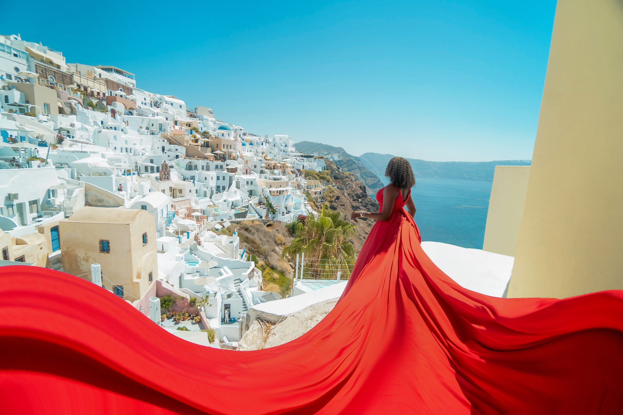 Robe volante rouge à Santorin - Dos en V, Tailles XS-XL, Location à 100 euros. Photographe vidéaste à Santorin|Séances photos de Robe volante Santorin|