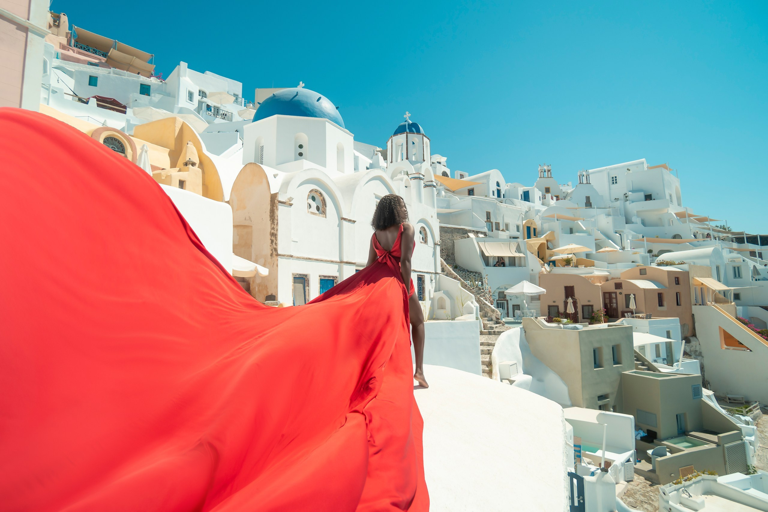 Robe volante rouge à Santorin - Dos en V, Tailles XS-XL, Location à 100 euros. Photographe vidéaste à Santorin|Séances photos de Robe volante Santorin|