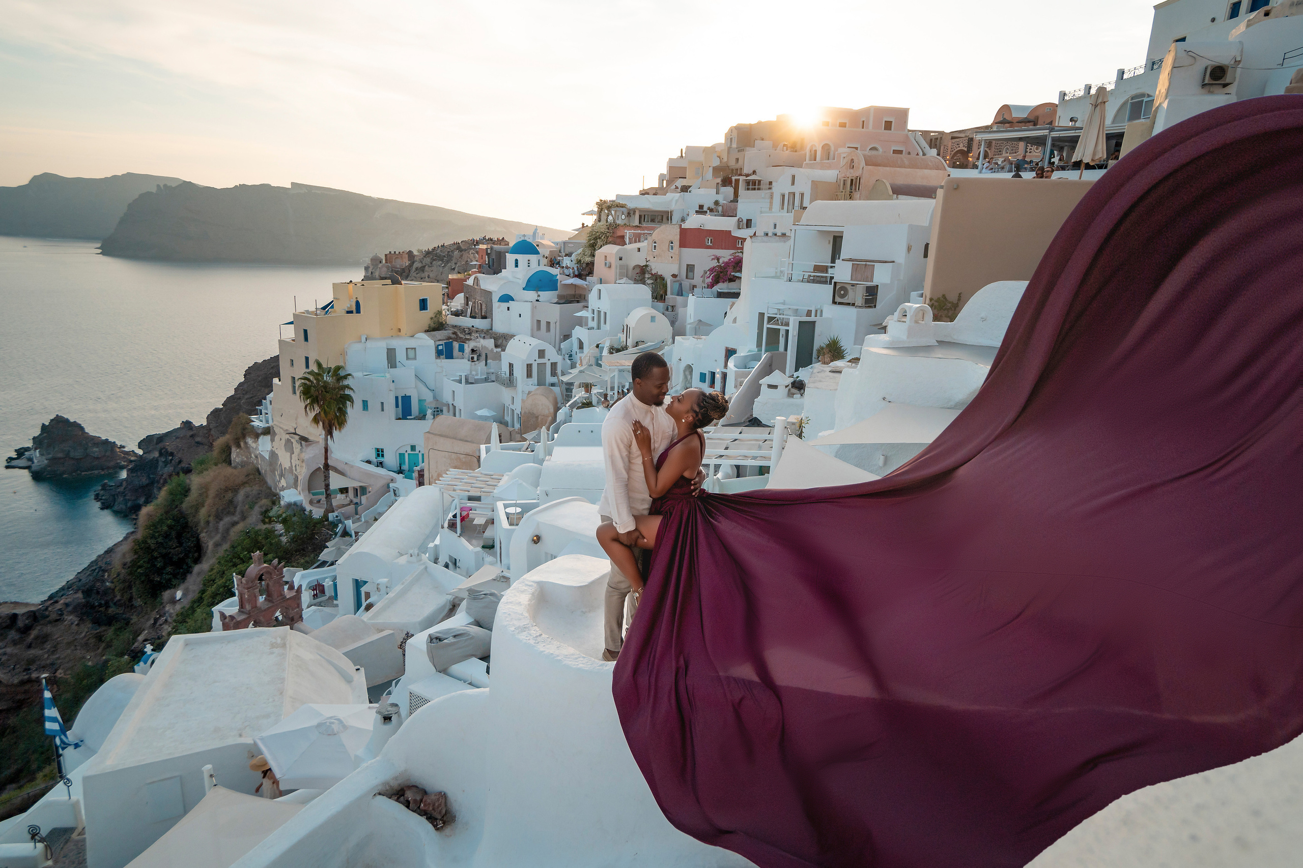 Photo session in Oia, Santorini at sunset, cherry flying dress. Photographer in Santorini SokoLOVE Alex| Flying Dress Santorini
