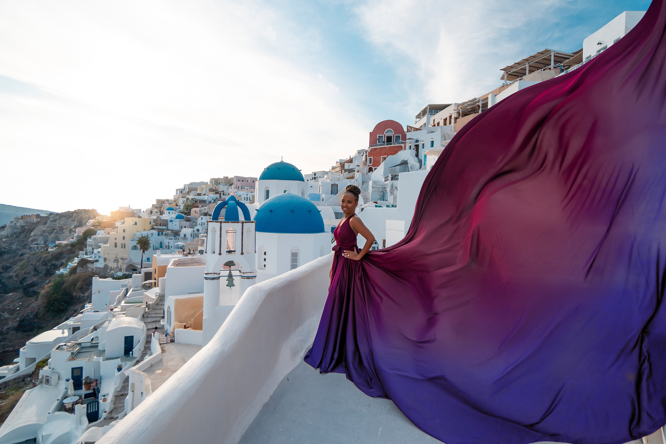 Photo session in Oia, Santorini at sunset, cherry flying dress. Photographer in Santorini SokoLOVE Alex| Flying Dress Santorini