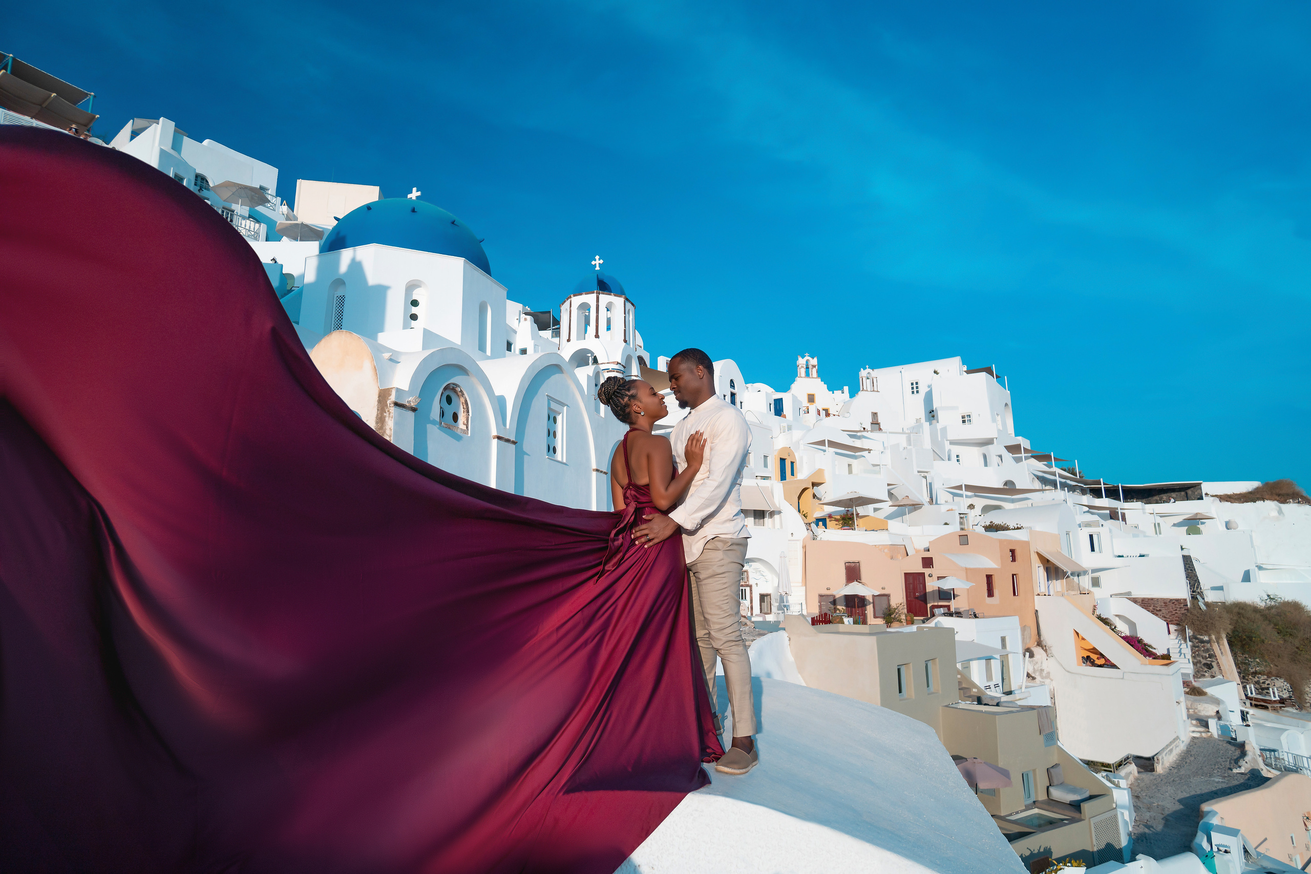 Photo session in Oia, Santorini at sunset, cherry flying dress. Photographer in Santorini SokoLOVE Alex| Flying Dress Santorini