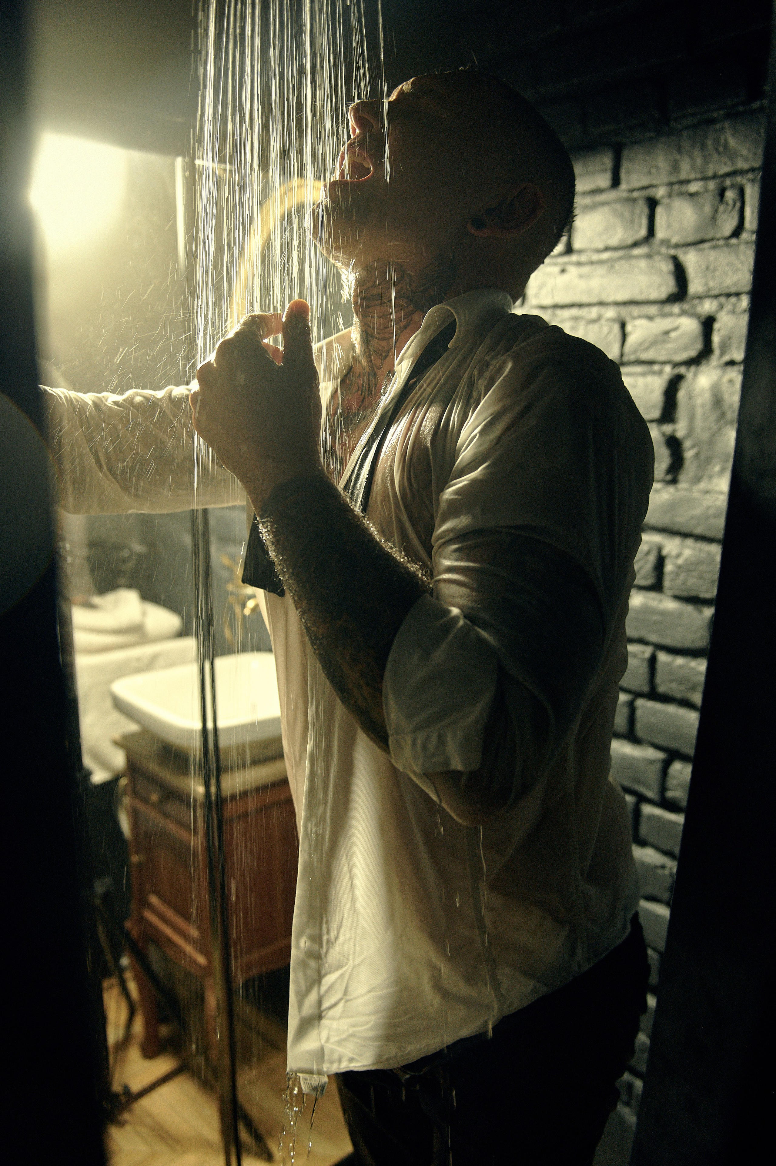 Zbliżenie – mężczyzna pije alkohol pod prysznicem