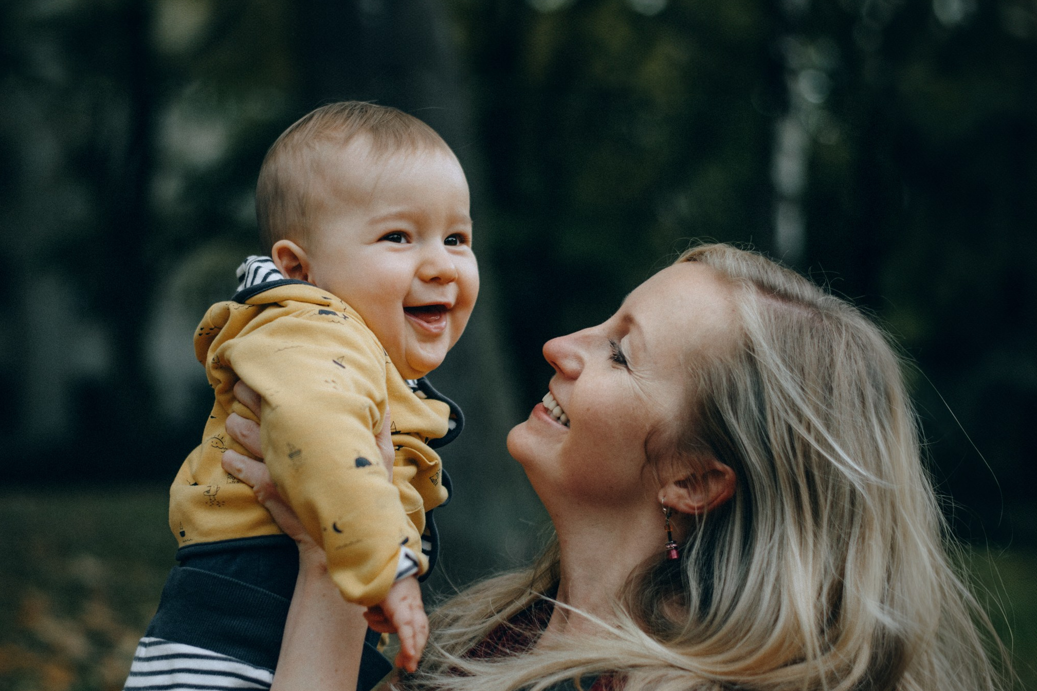 Мама подбрасывает малыша на руках — детская фотосессия в Дрездене
