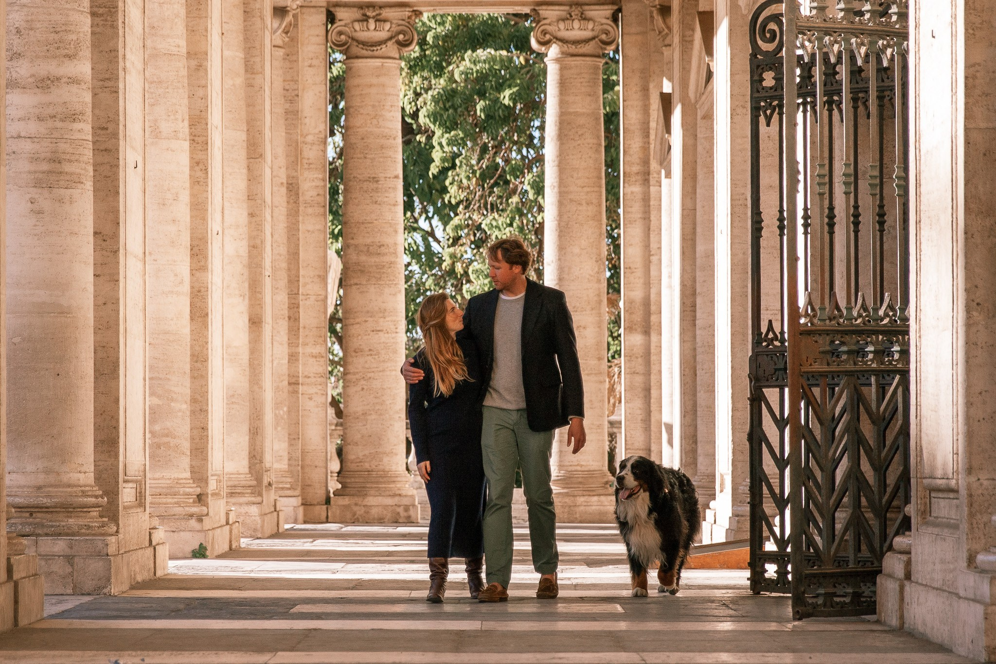 A couple holding hands while walking through a charming cobblestone street in Rome.