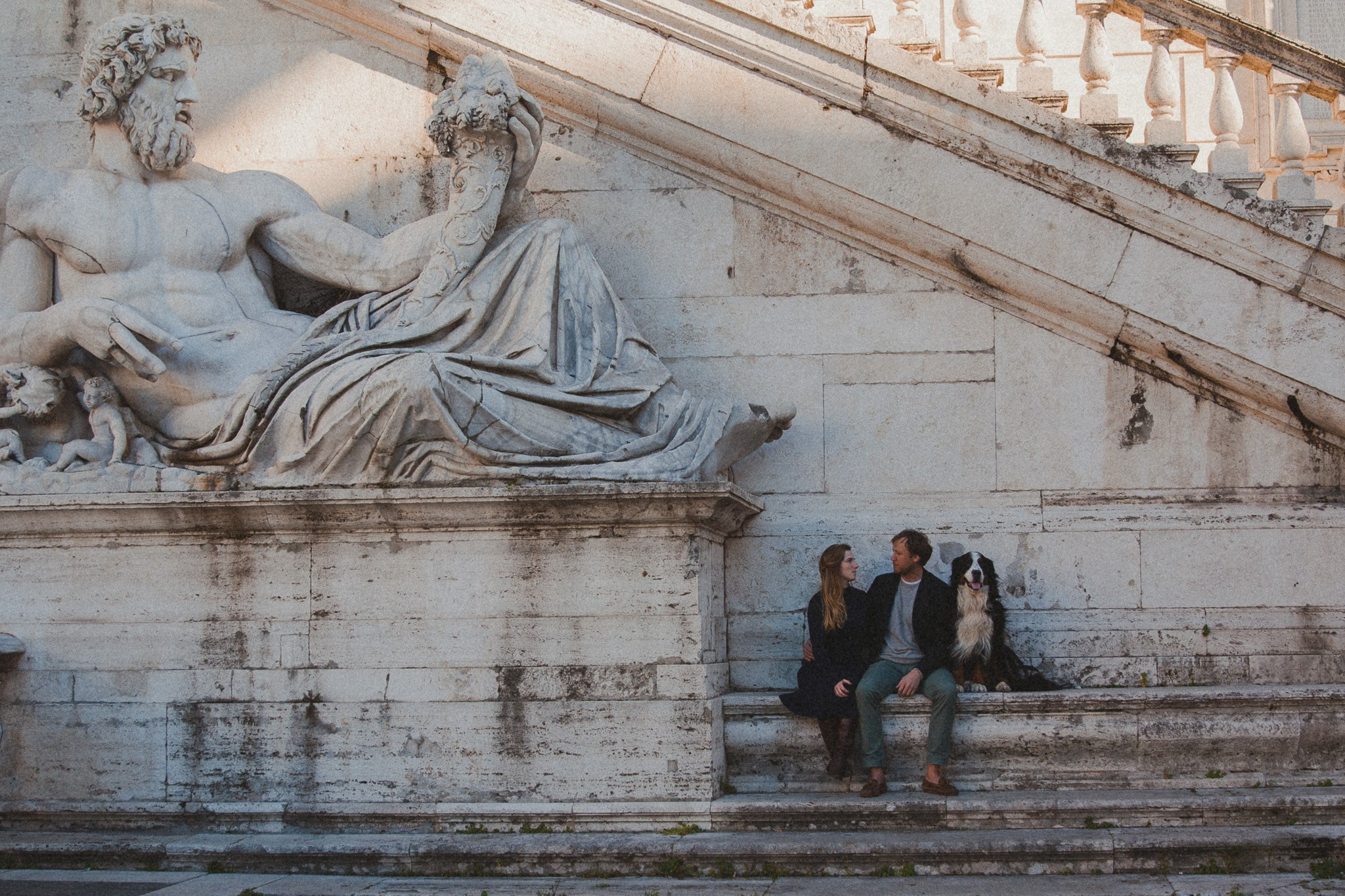 A couple sitting together at Piazza Campidoglio at sunset.