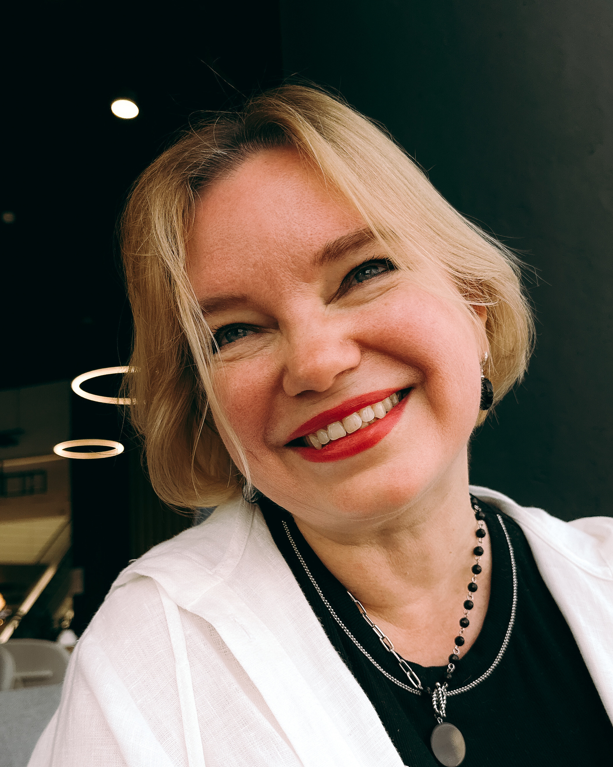 A blond lady smiling. Online photo shoot.