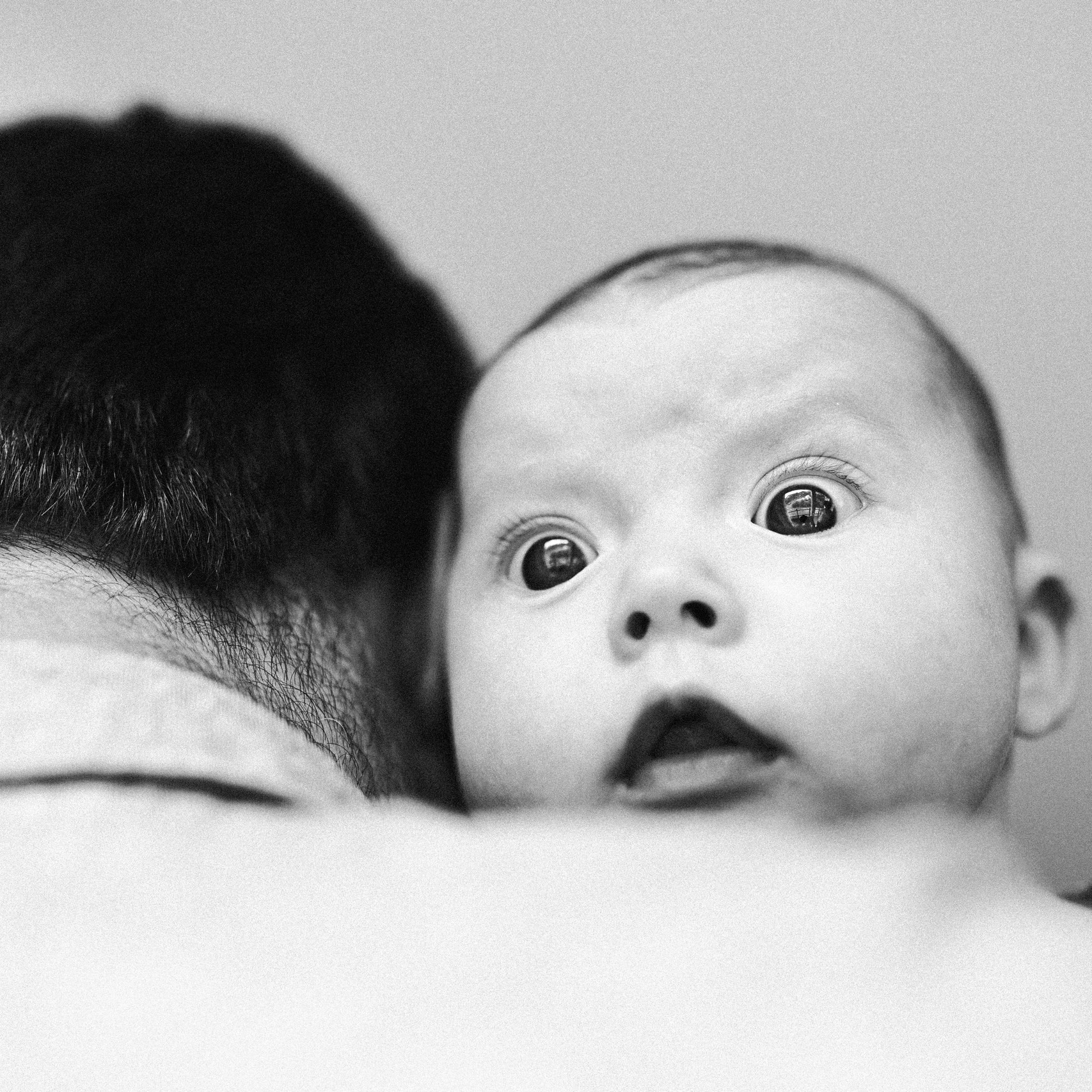 Das kleine Mädchen schaut über die Schulter ihres Vaters hinweg