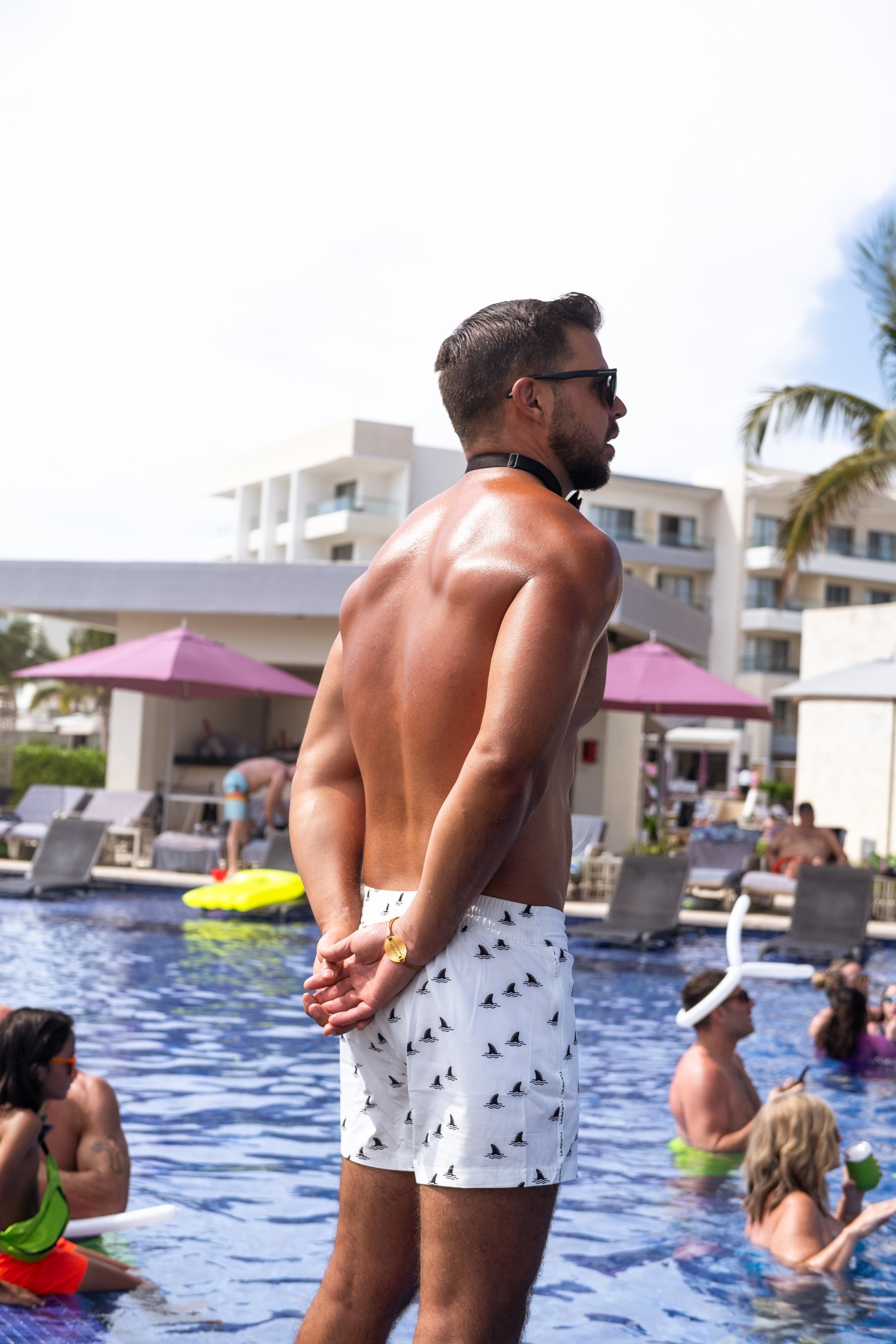 Groom standing in the pool surrounded by foam, waiting for bride to arrive on a float.