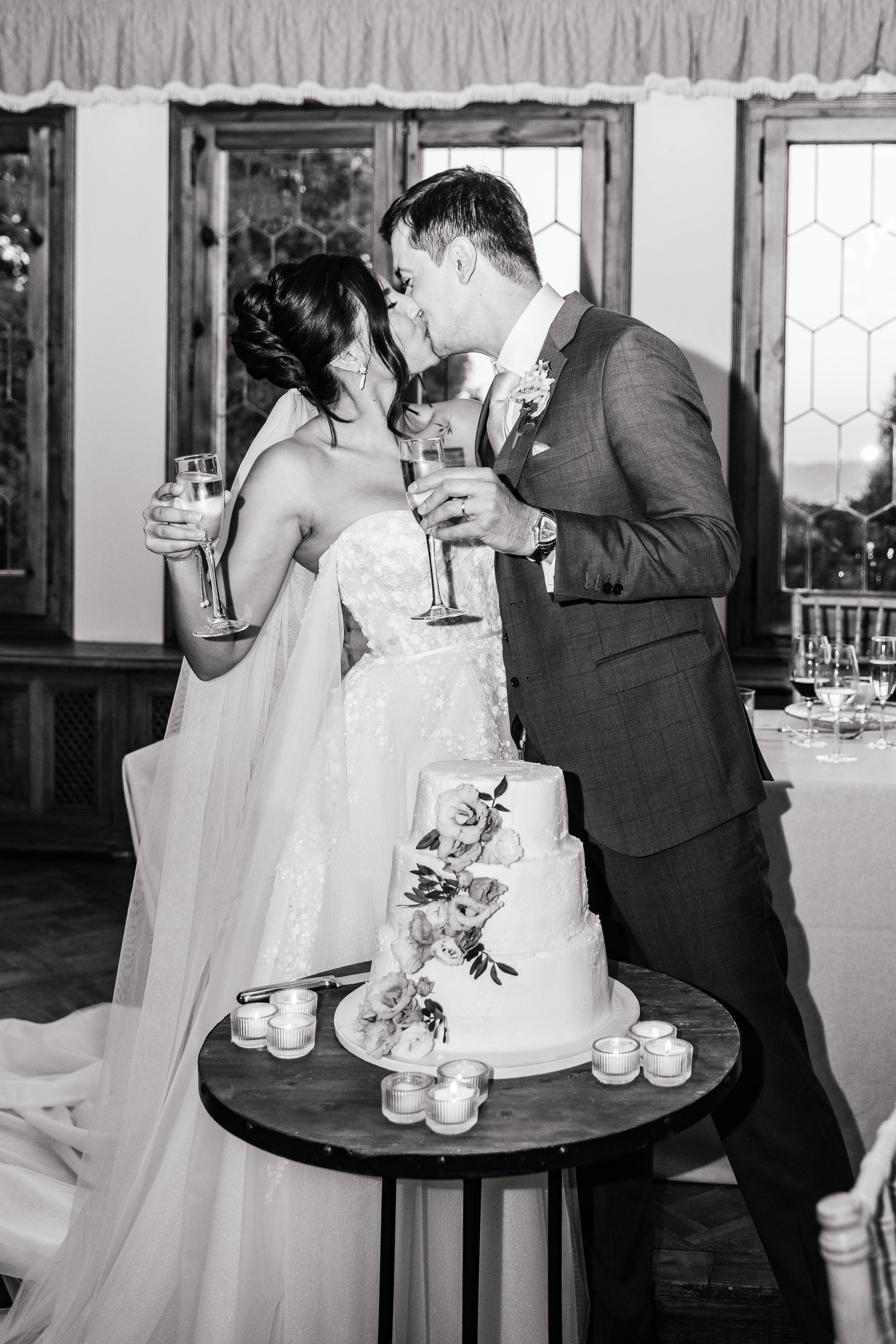 Passionate kiss of bride and groom after cutting the cake 