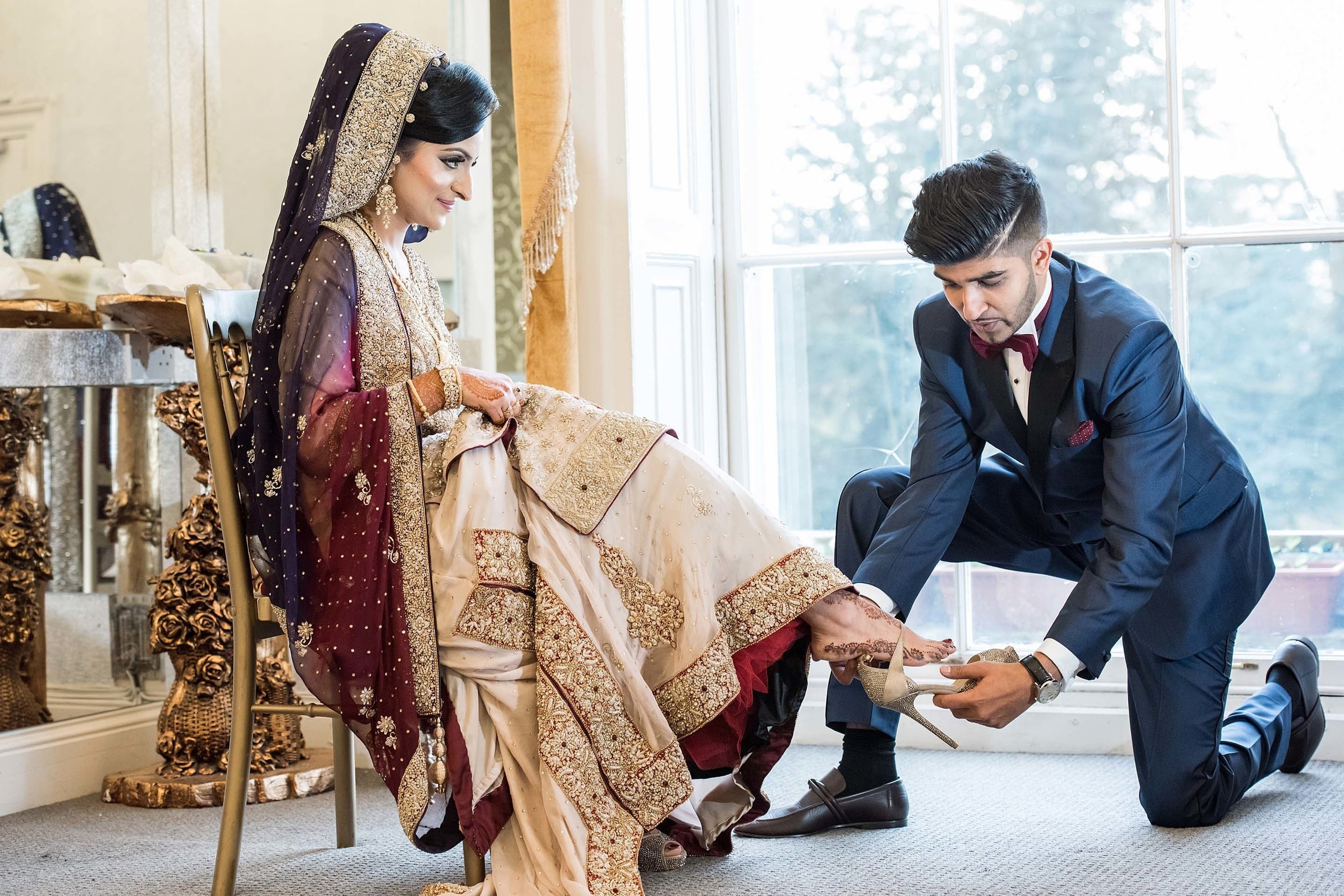 Wedding photographer Newland Manor London UK Nikon D850 Groom helping the bride to put her shoes on