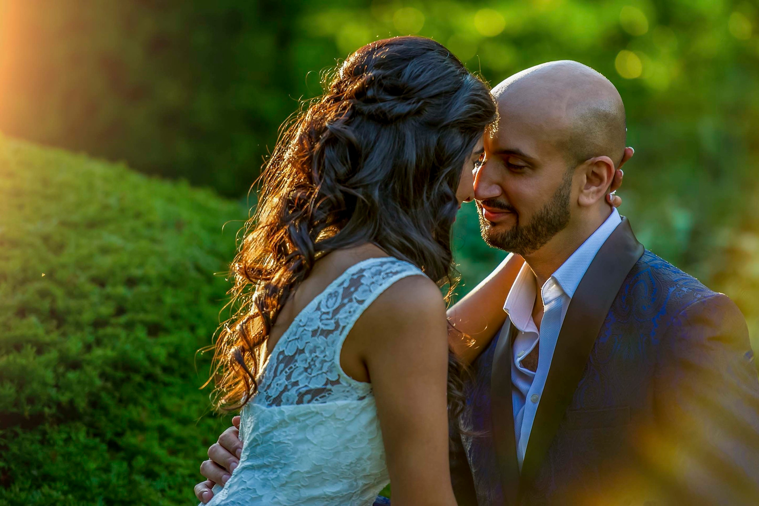 Bride and groom sharing an intimate moment in golden hour light surrounded by nature  at Ascot Racecourse, UK