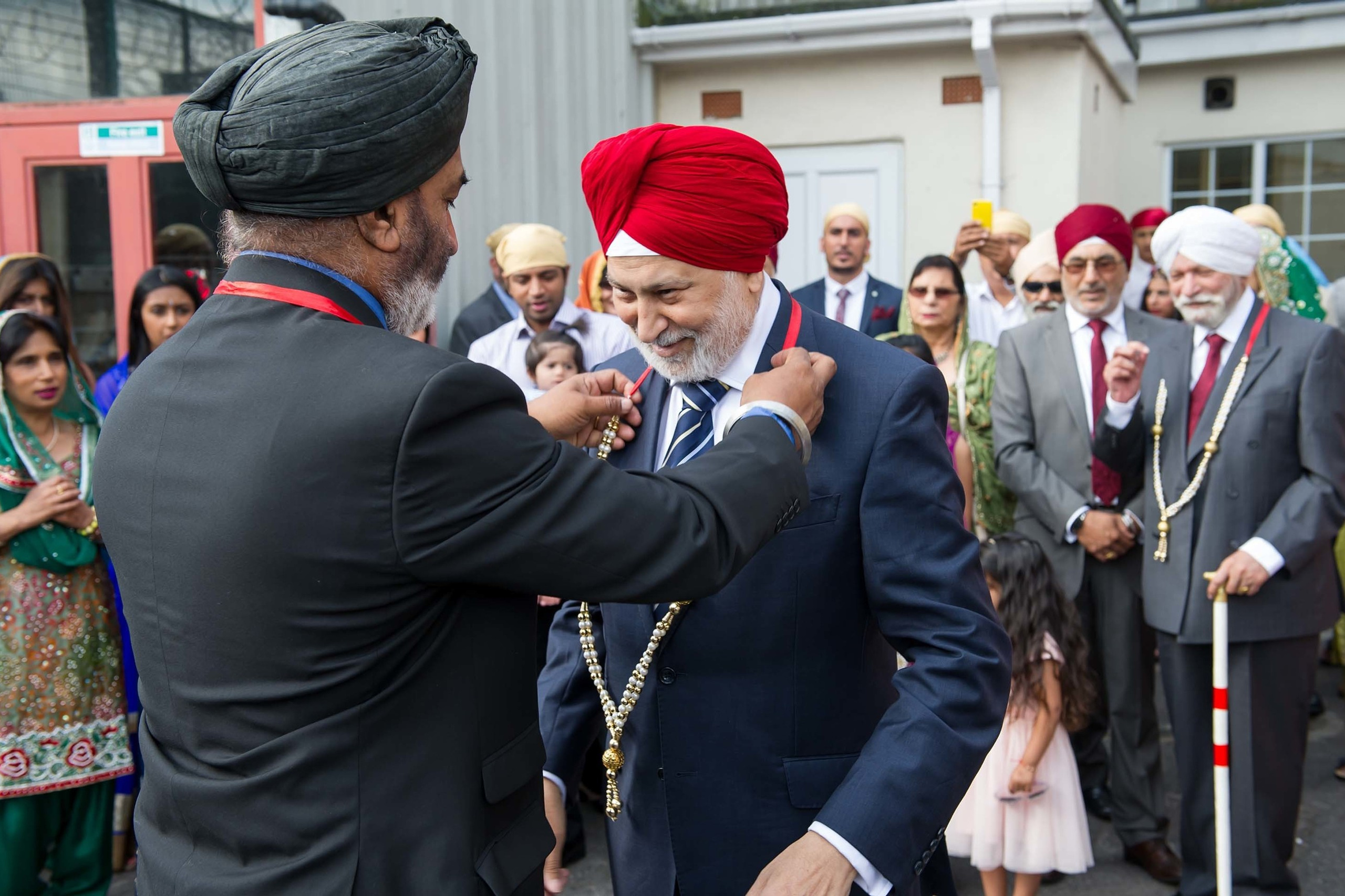 Wedding photographer Guru Nanak Darbar Gurdwara London UK Nikon D850 Relatives exchanging flower garlands on asian wedding