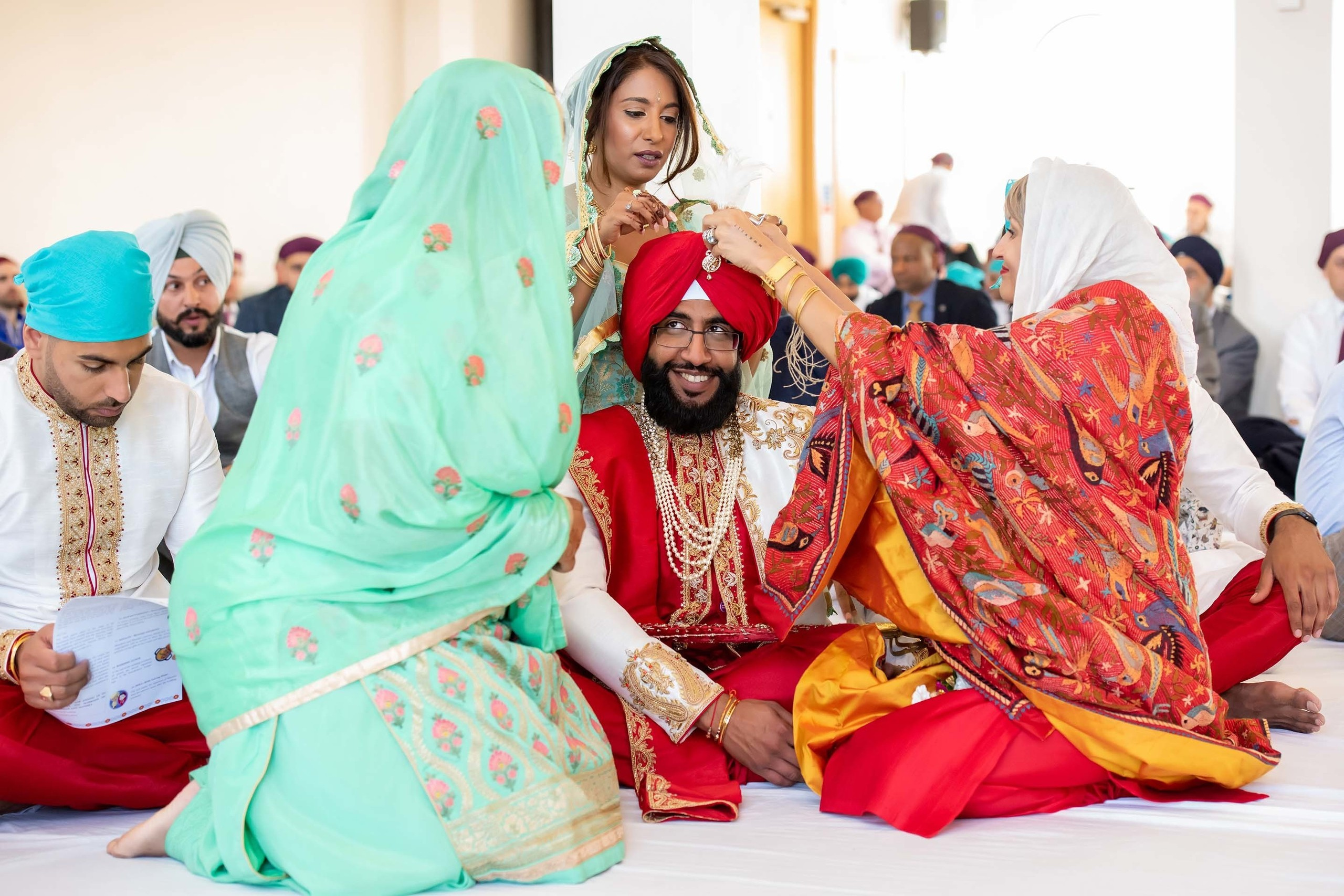 Wedding photographer Guru Nanak Darbar Gurdwara London UK Nikon D850 family around groom during Sikh religious ceremony
