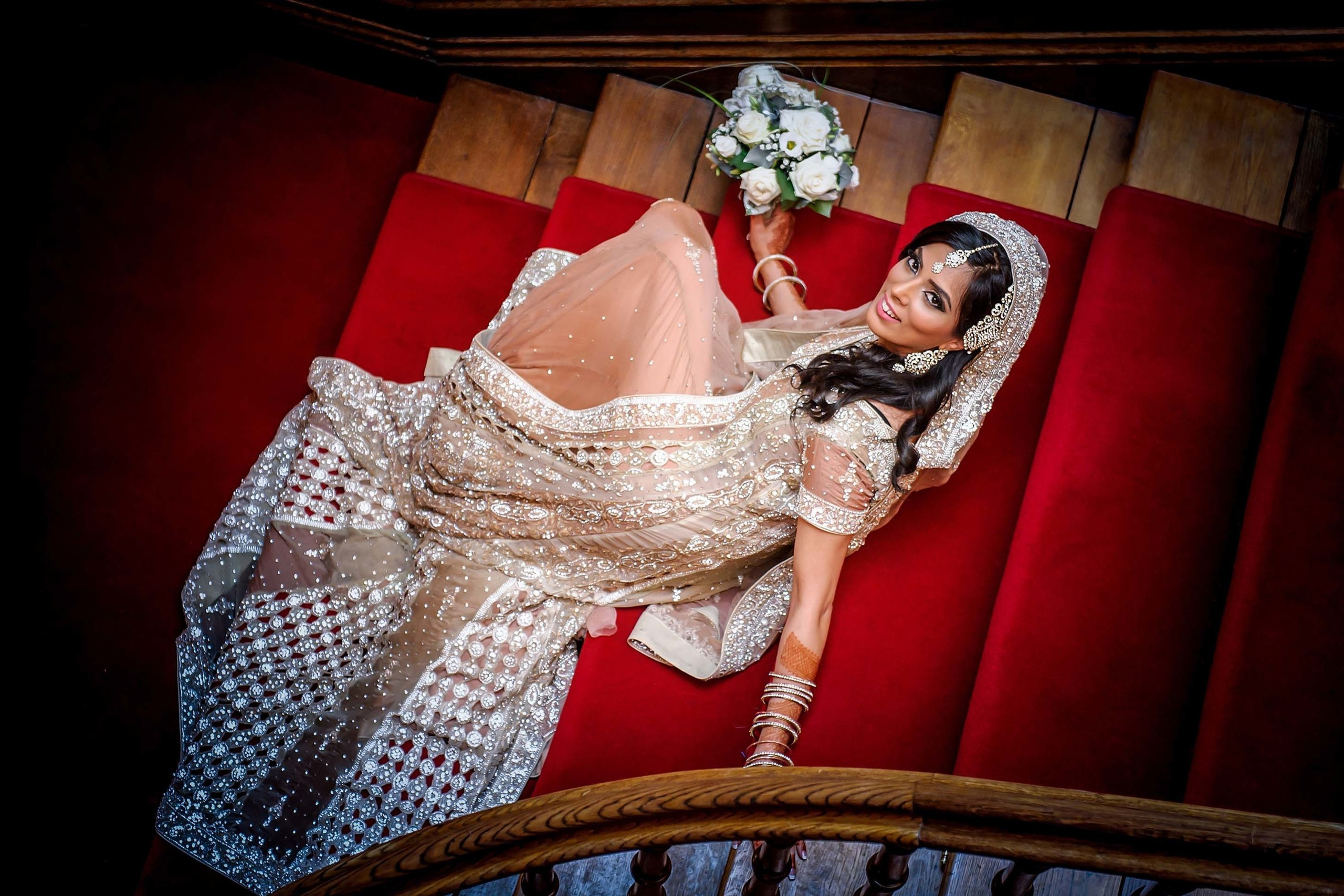 Wedding photographer Froyle Park, Hampshire, UK Nikon D850  Asian Bride posing on the stairs lehenga