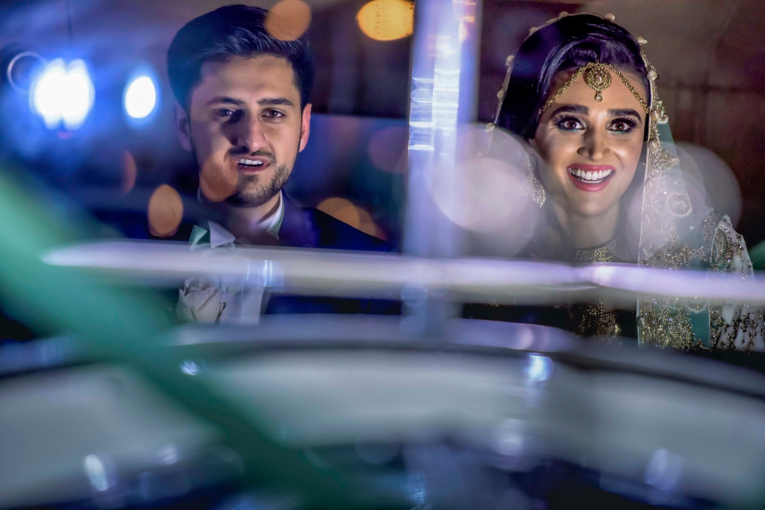 Asian wedding photo session with groom whispering at his bride under dramatic sky at Meridian Grand, London UK