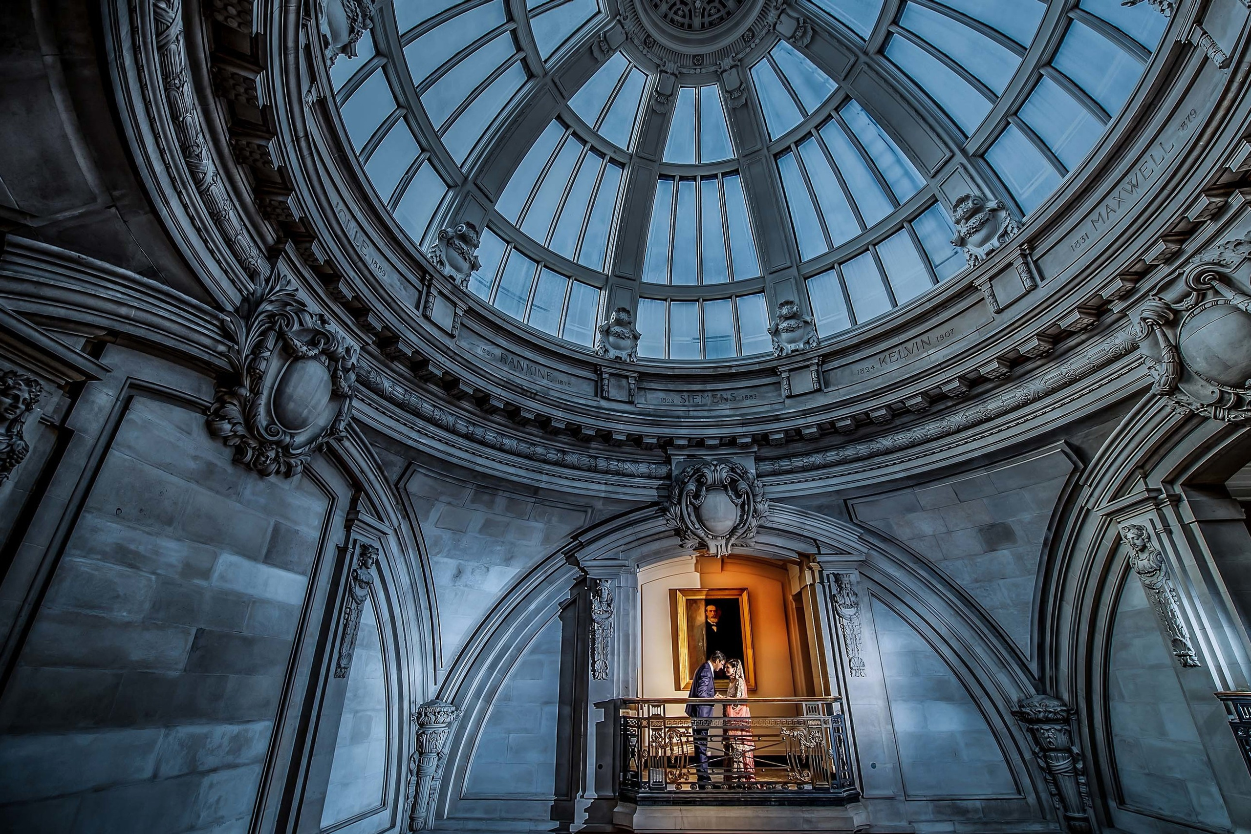 Asian couple touching foreheads and holding hands on the Balcony and Glass Dome at One George Street, London UK. 