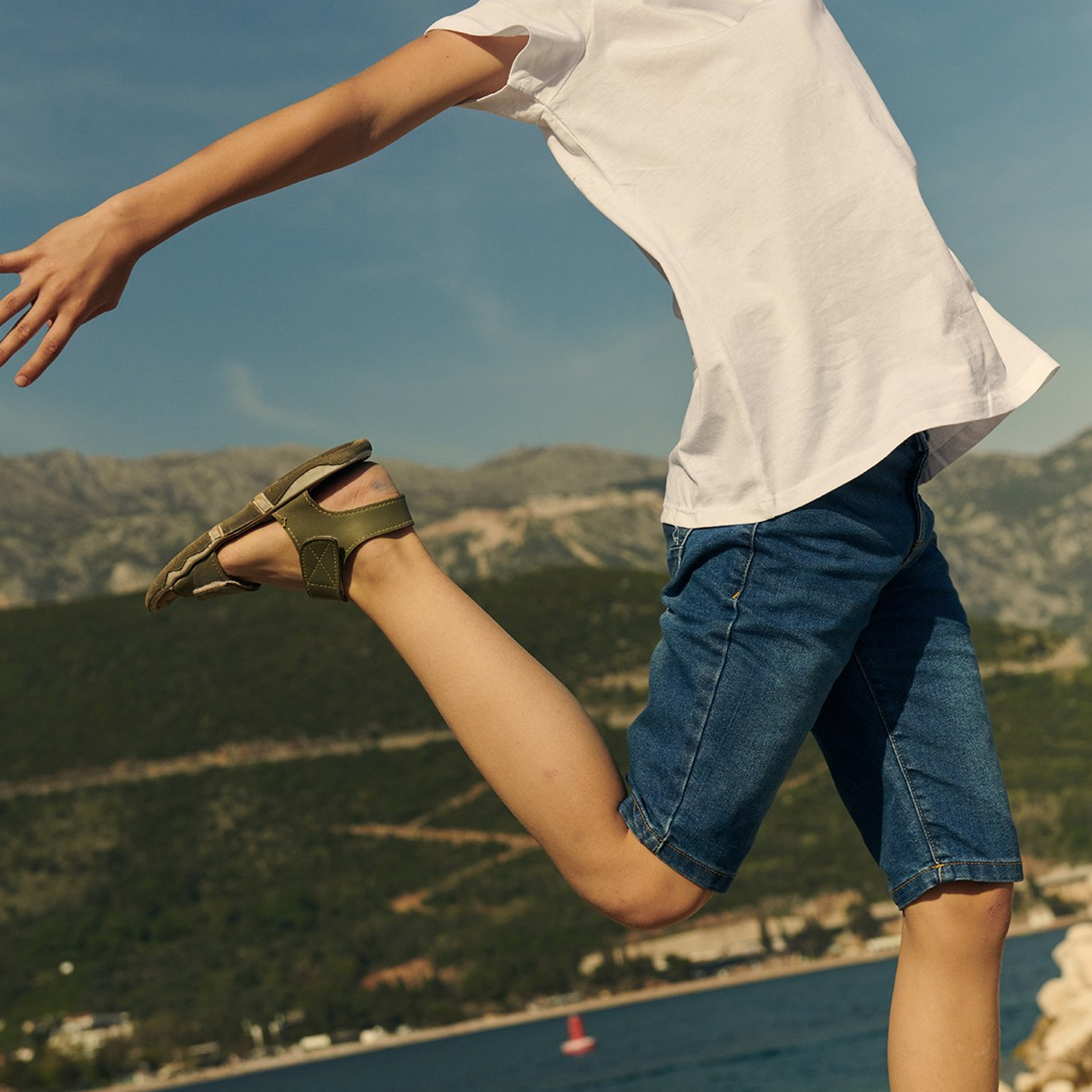 Editorial kids fashion photography featuring a child in trendy clothing, styled for seasonal collection showcasing careless childhood