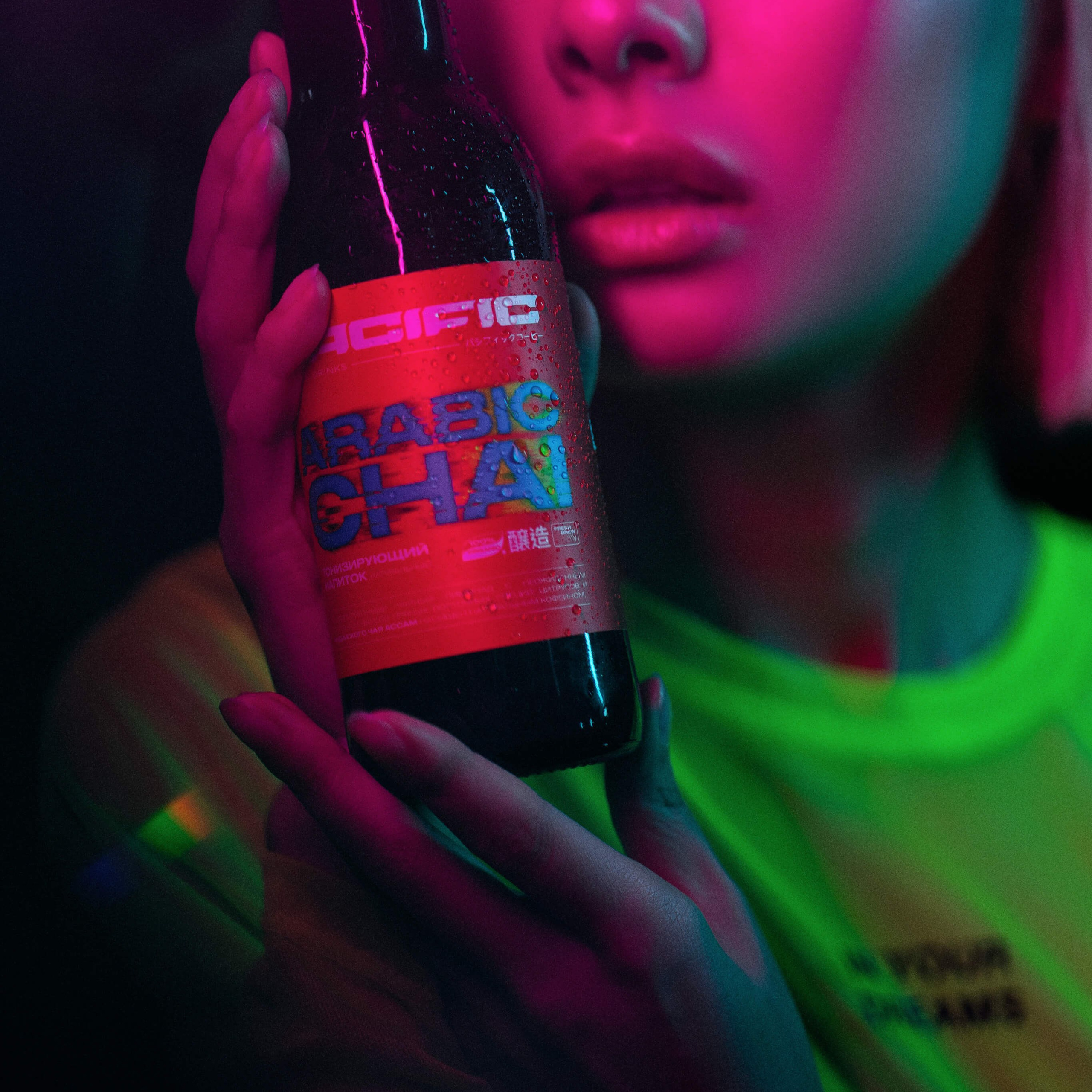 A moody and atmospheric shot of a person holding a bottle of 'Arabic Chai,' with their face partially illuminated by the vibrant neon glow reflecting off the bottle, creating a sense of allure and nocturnal energy