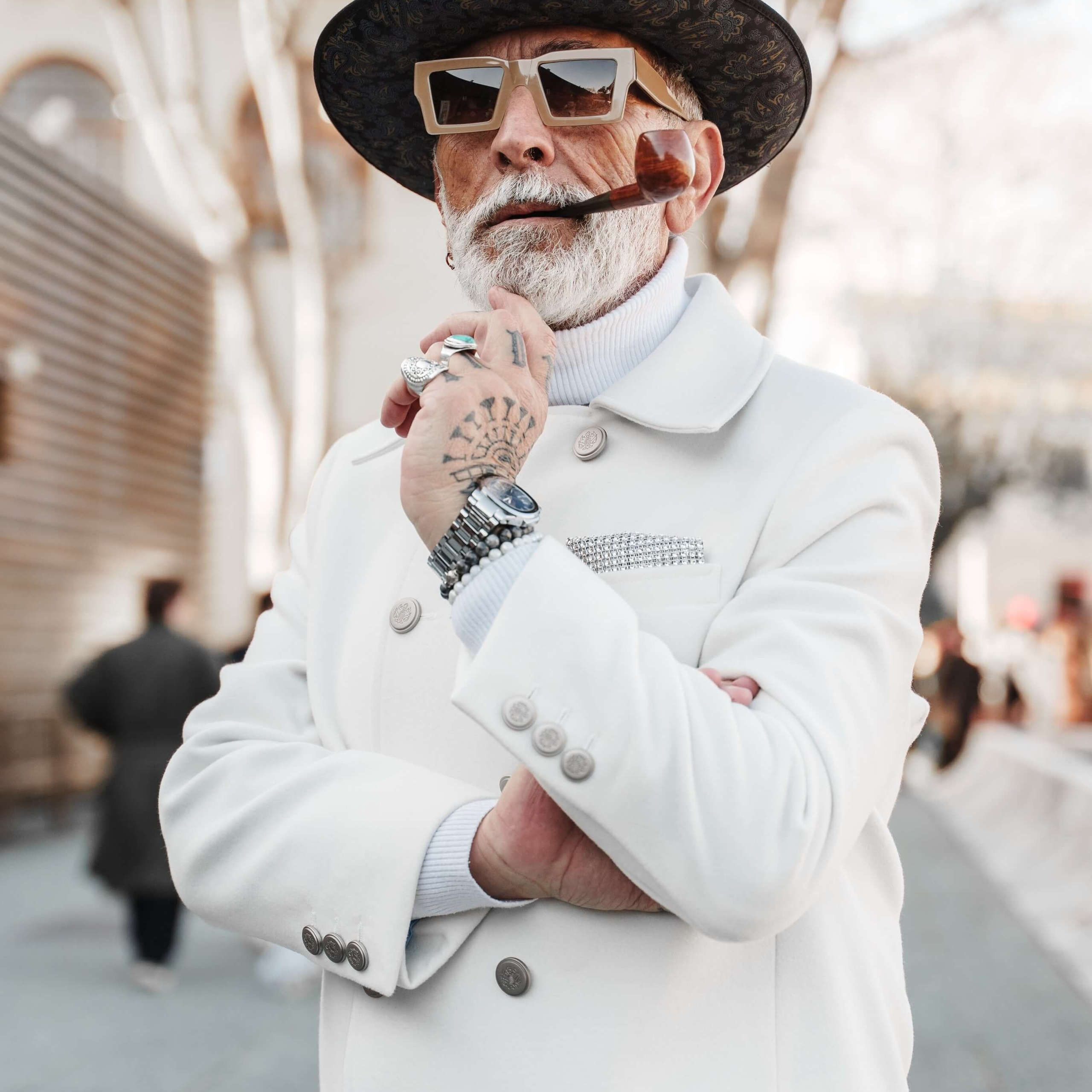 Portrait of a stylish man in a white double-breasted coat and hat, his attitude and fashion sense exuding confidence and classic charm.