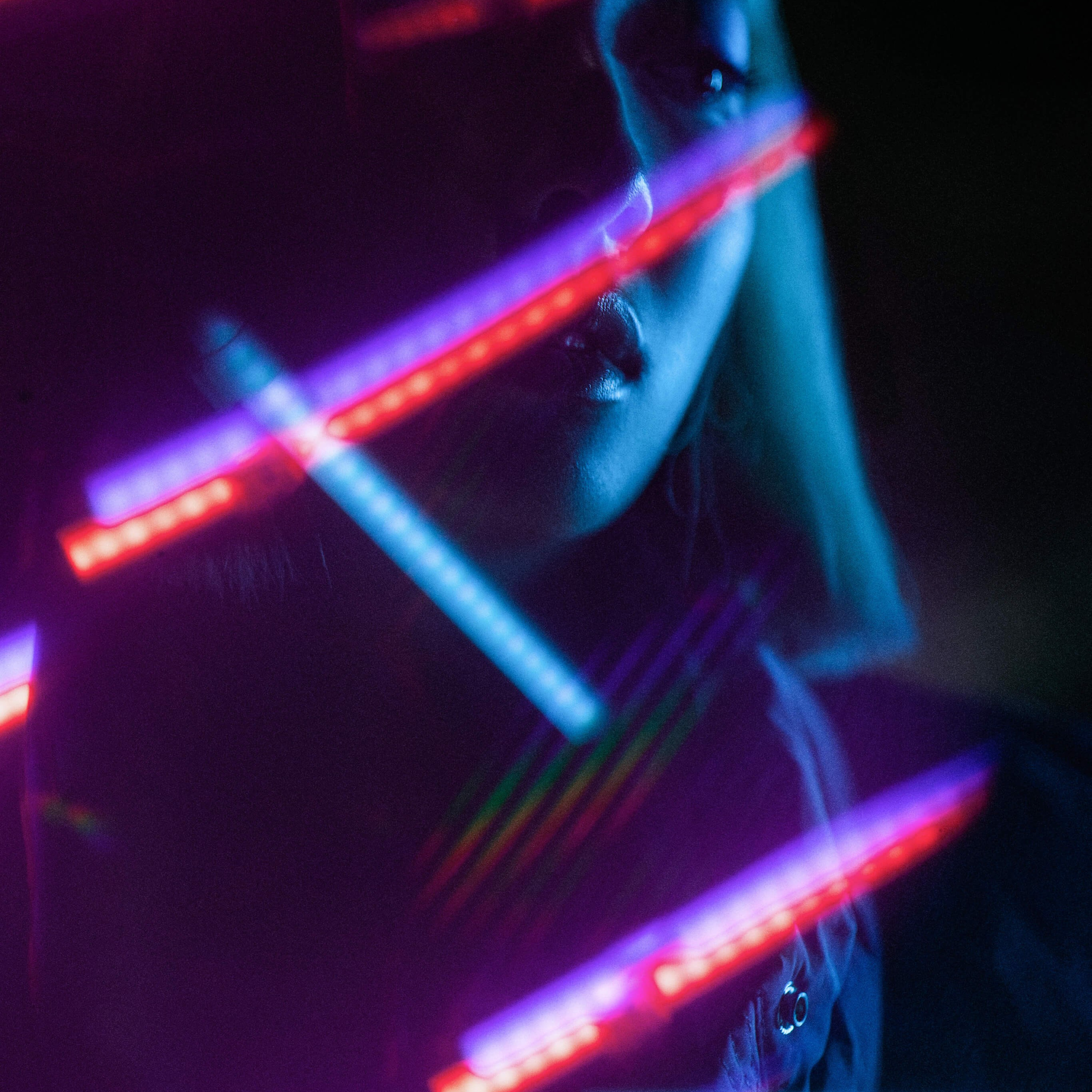 A close-up shot where neon lights paint a surreal portrait, highlighting the subject's features with a mesmerizing glow