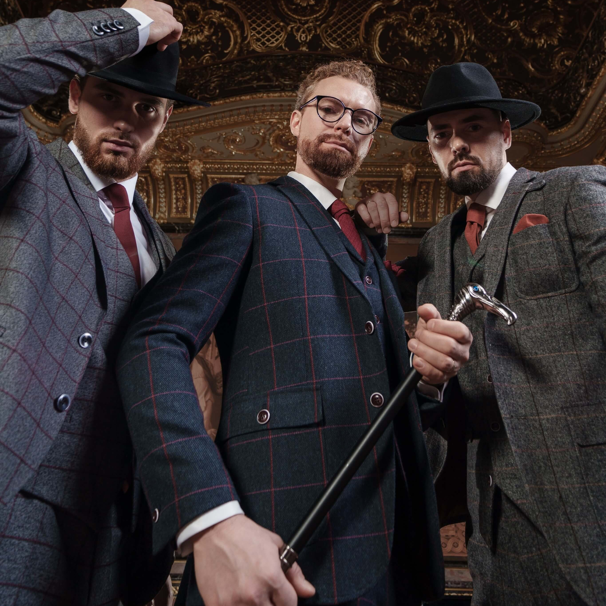 A photo of trio of stylish men donning elegant plaid suits and vintage hats, posing in a luxurious Milanese interior with opulent golden decorations