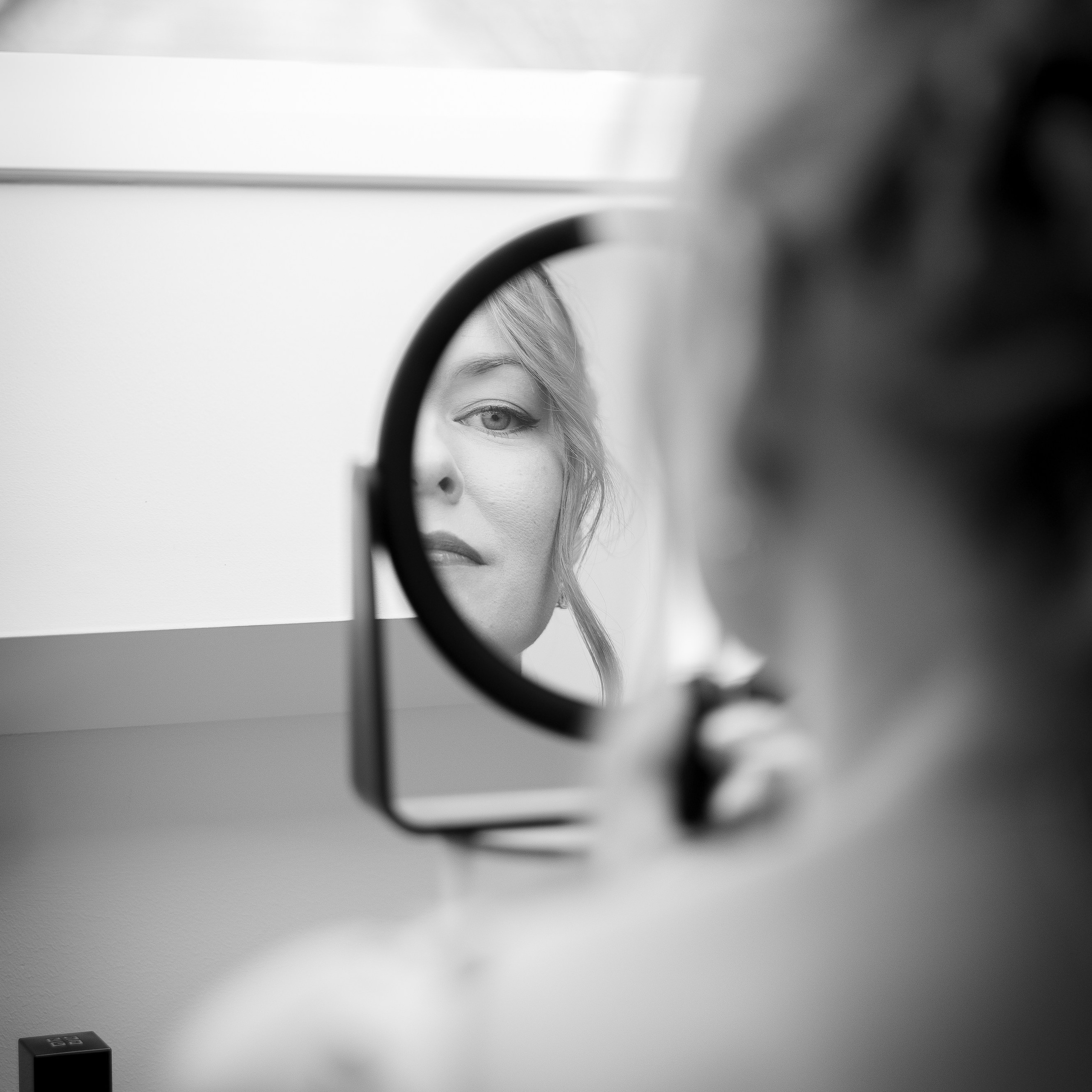 Bruid brengt make-up aan voor de spiegel tijdens huwelijksvoorbereiding - Kapture Fotografie