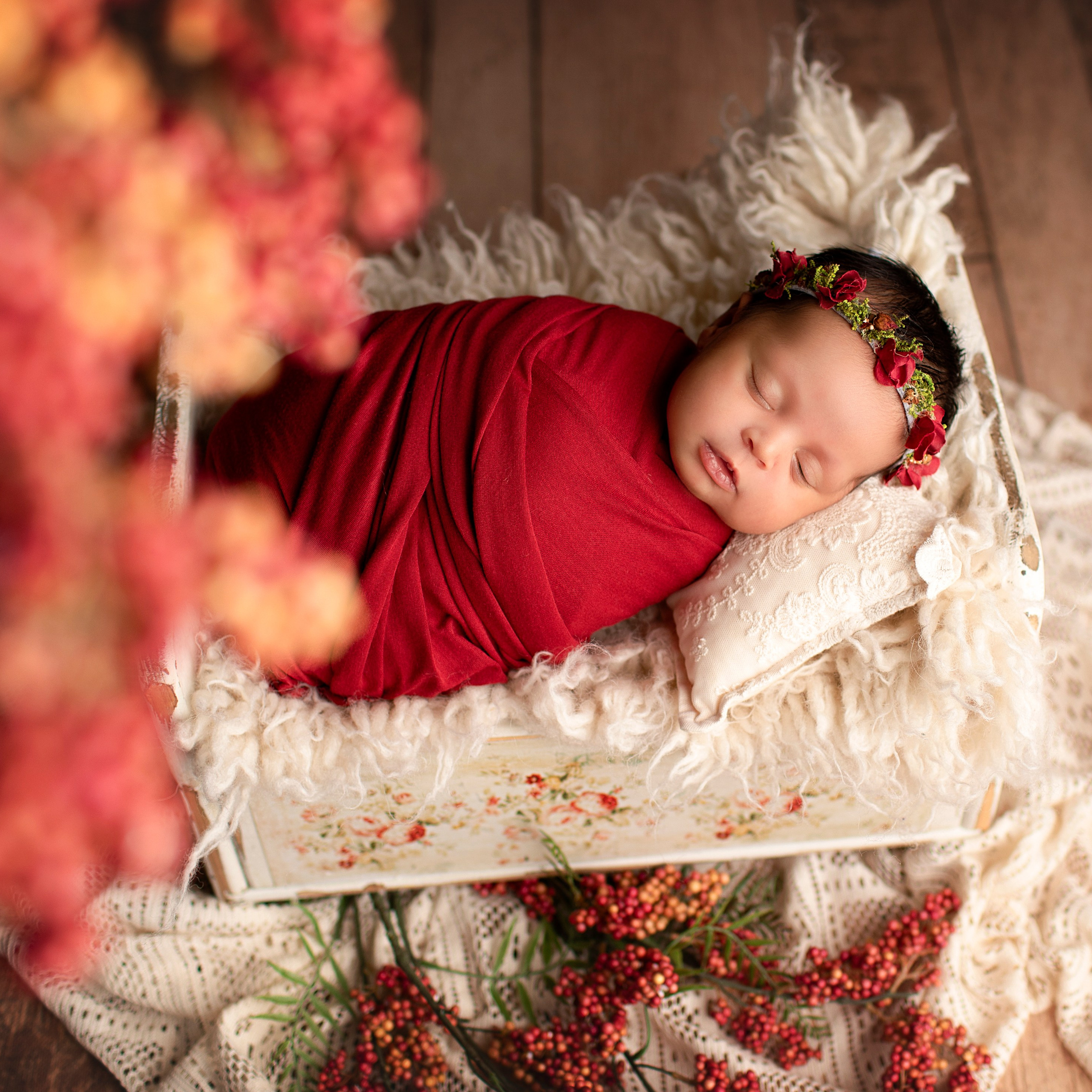 "Söt nyfödd baby som ligger i en mjuk filt med ett lugnt uttryck. Bilden är utmärkt för webbplatser som fokuserar på babyfotografi och nyfödda bilder."