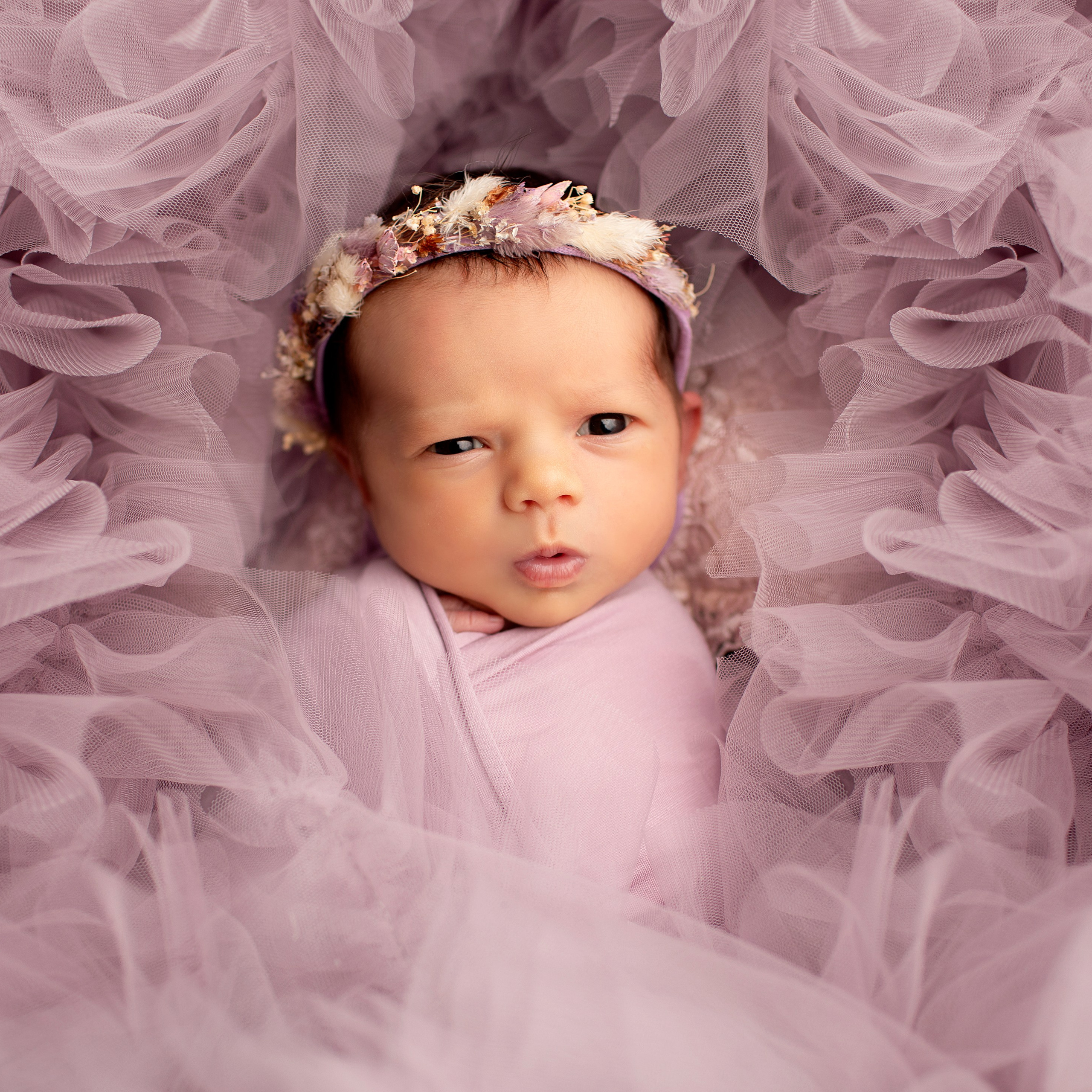 "Nyfödda barn som ligger tillsammans i en mjuk filt. Bilden visar deras söta ansikten och små händer, perfekt för att illustrera nyfödda fotograferingar och babyfotografi."