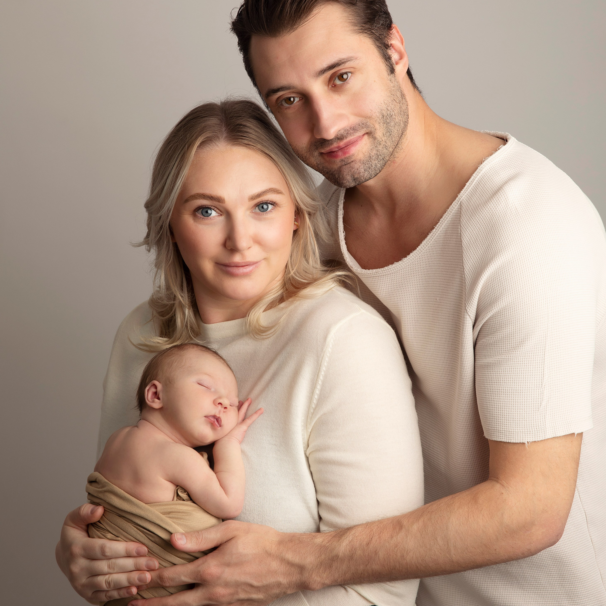 "Familjefotografi som visar föräldrar med deras nyfödda baby och äldre syskon. Bilden fångar den kärleksfulla och glada familjebanden samt den speciella stunden av att välkomna ett nytt familjemedlem."