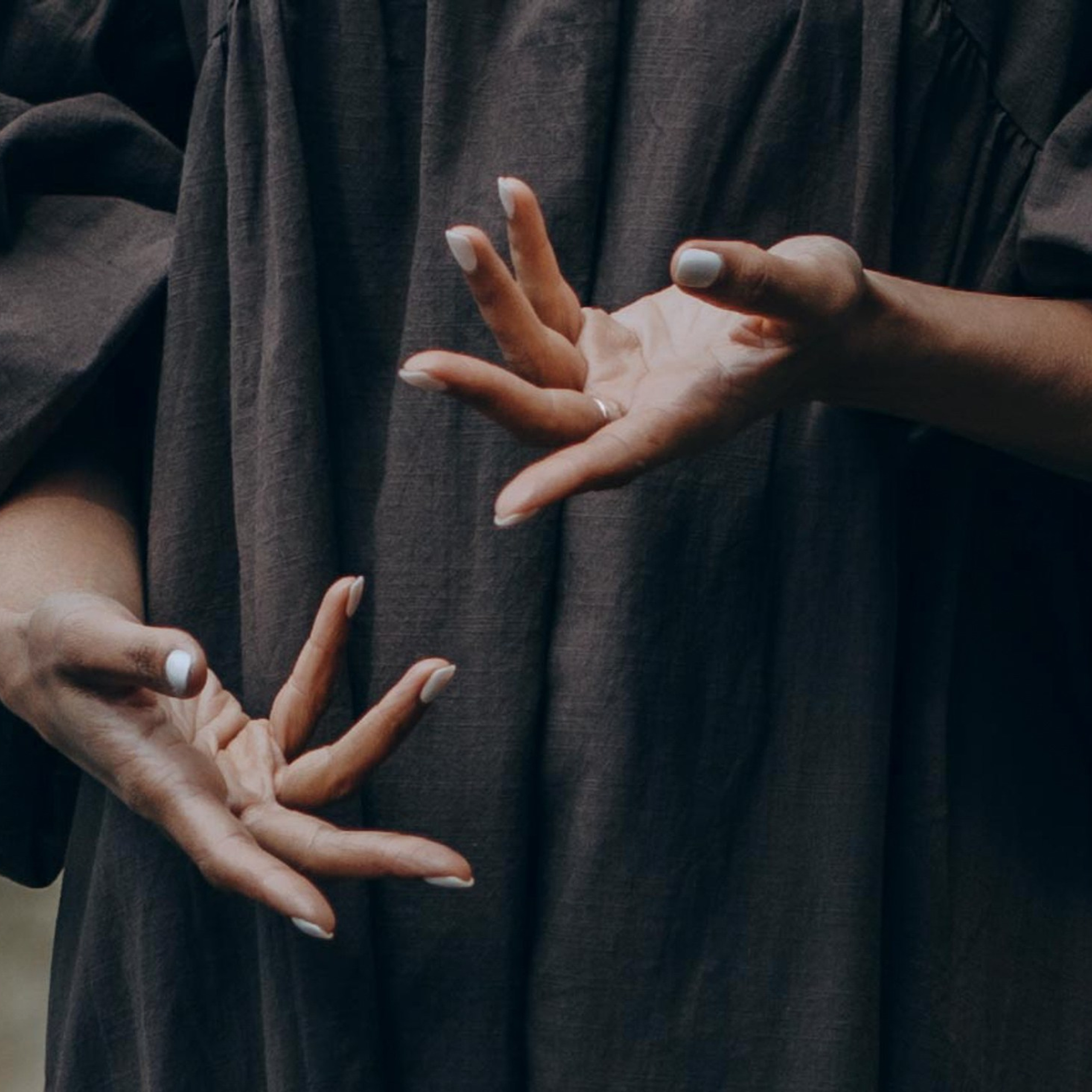 Крупный план рук в движении, тёмный фон — креативная портретная фотография