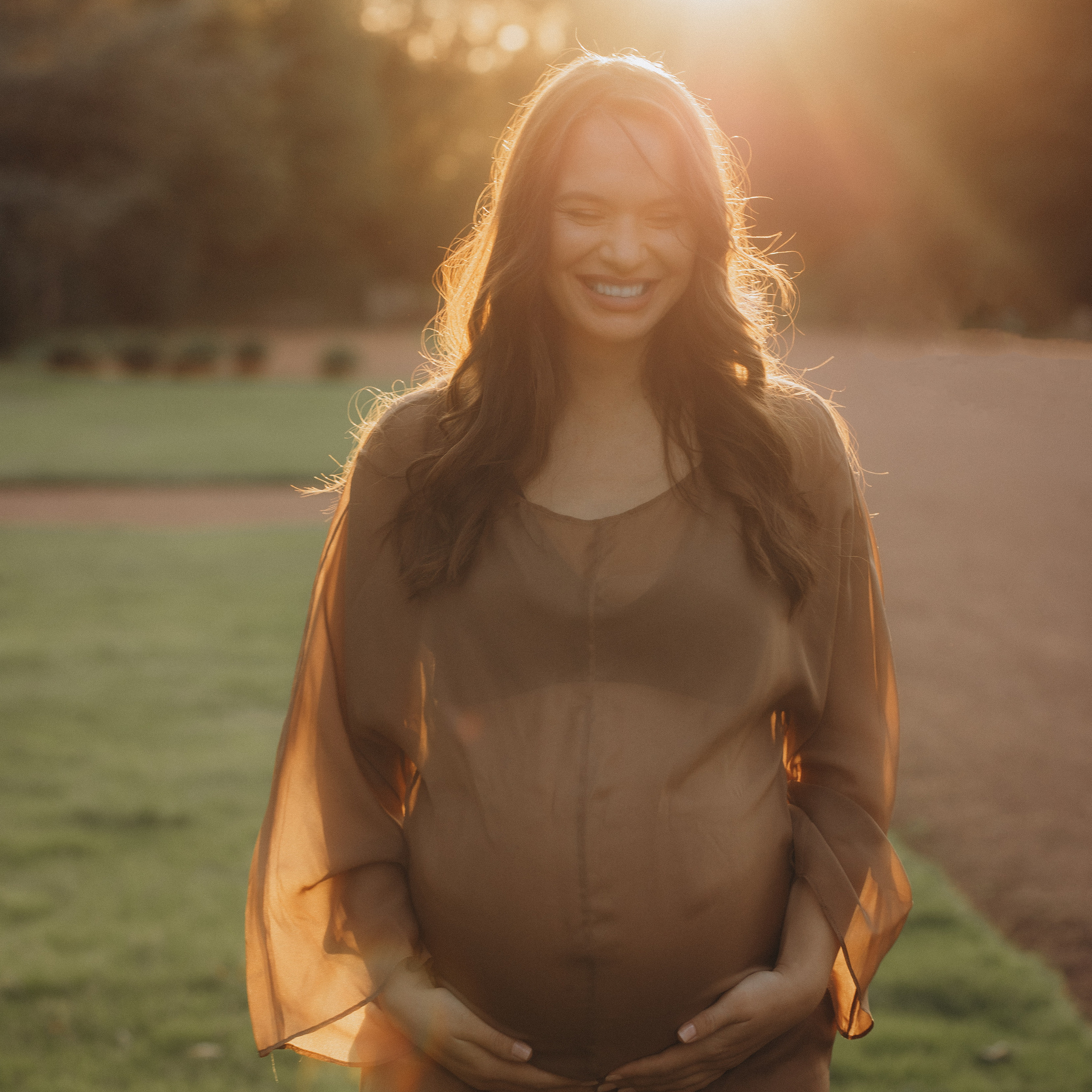 Babybauch beim Sonnenuntergang
